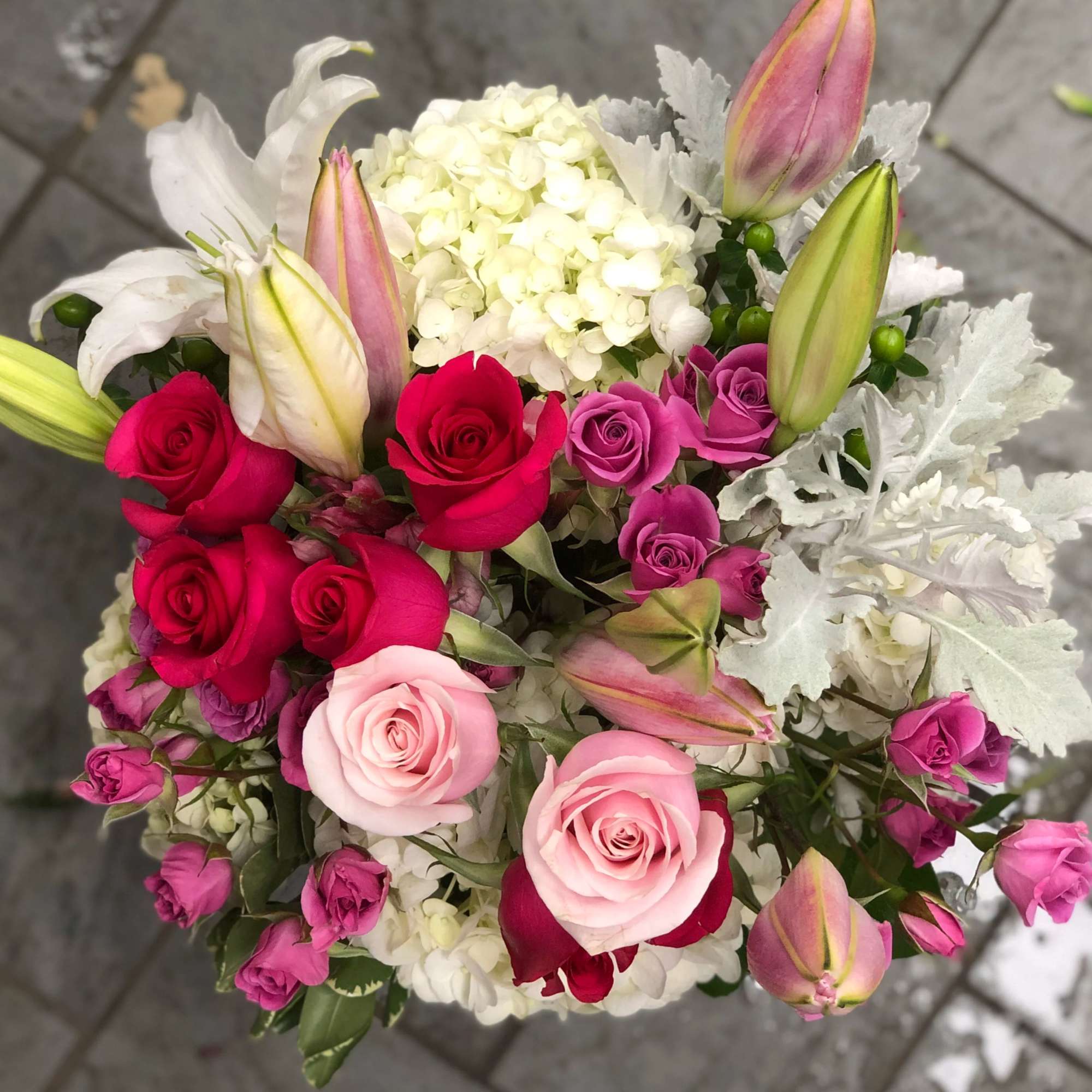 Bouquet of pink and red roses with white lilies and hydrangea