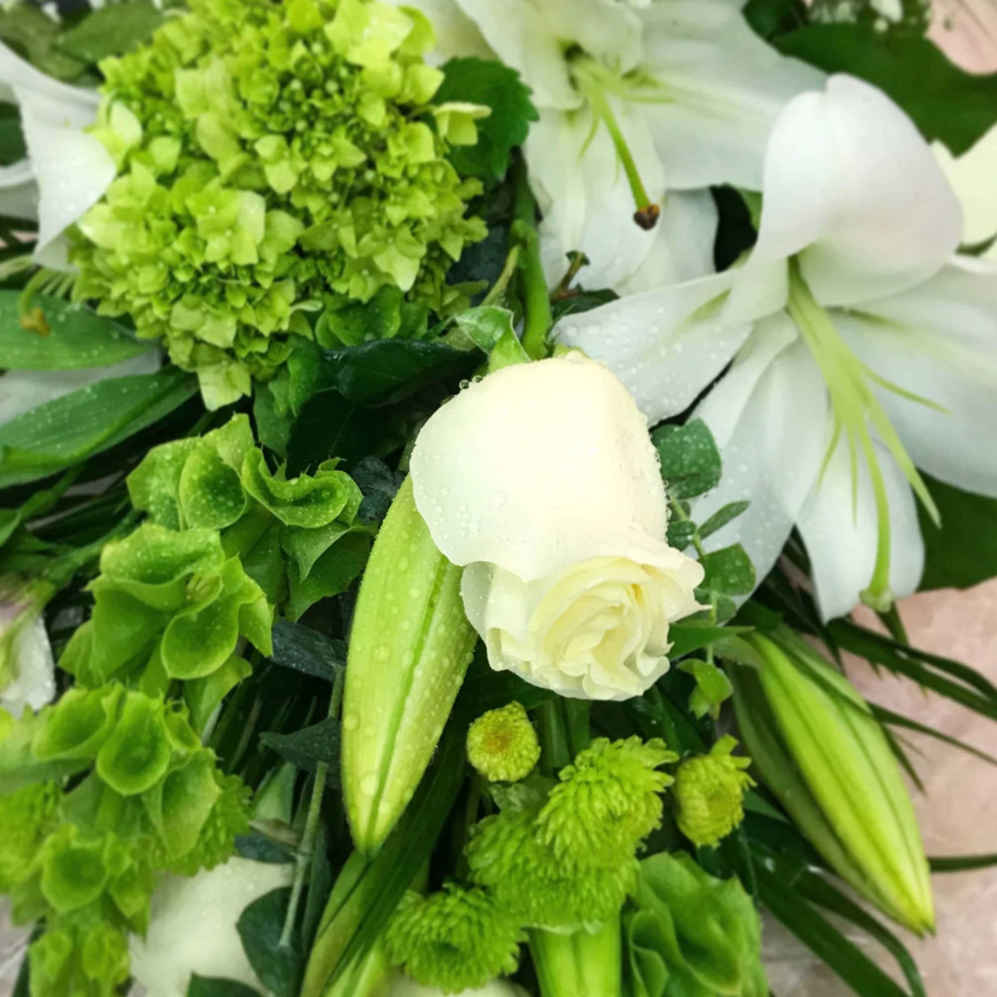 White lilies and green flowers in a bouquet