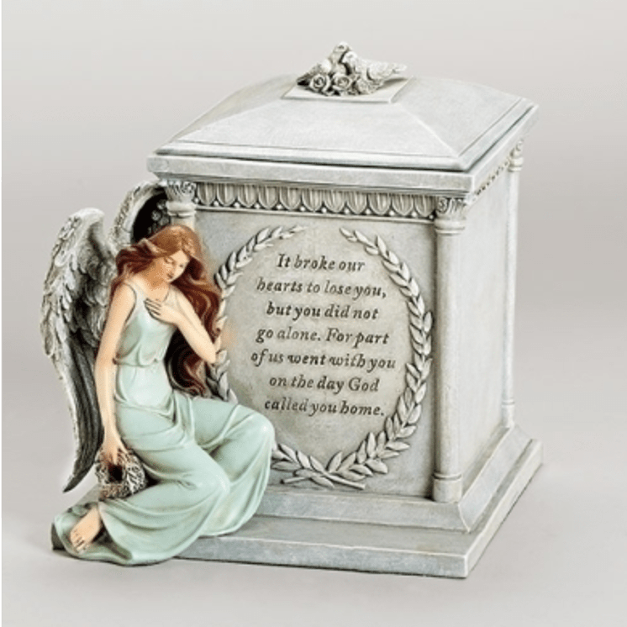 Angel figurine beside a memorial urn with an engraved sympathy message