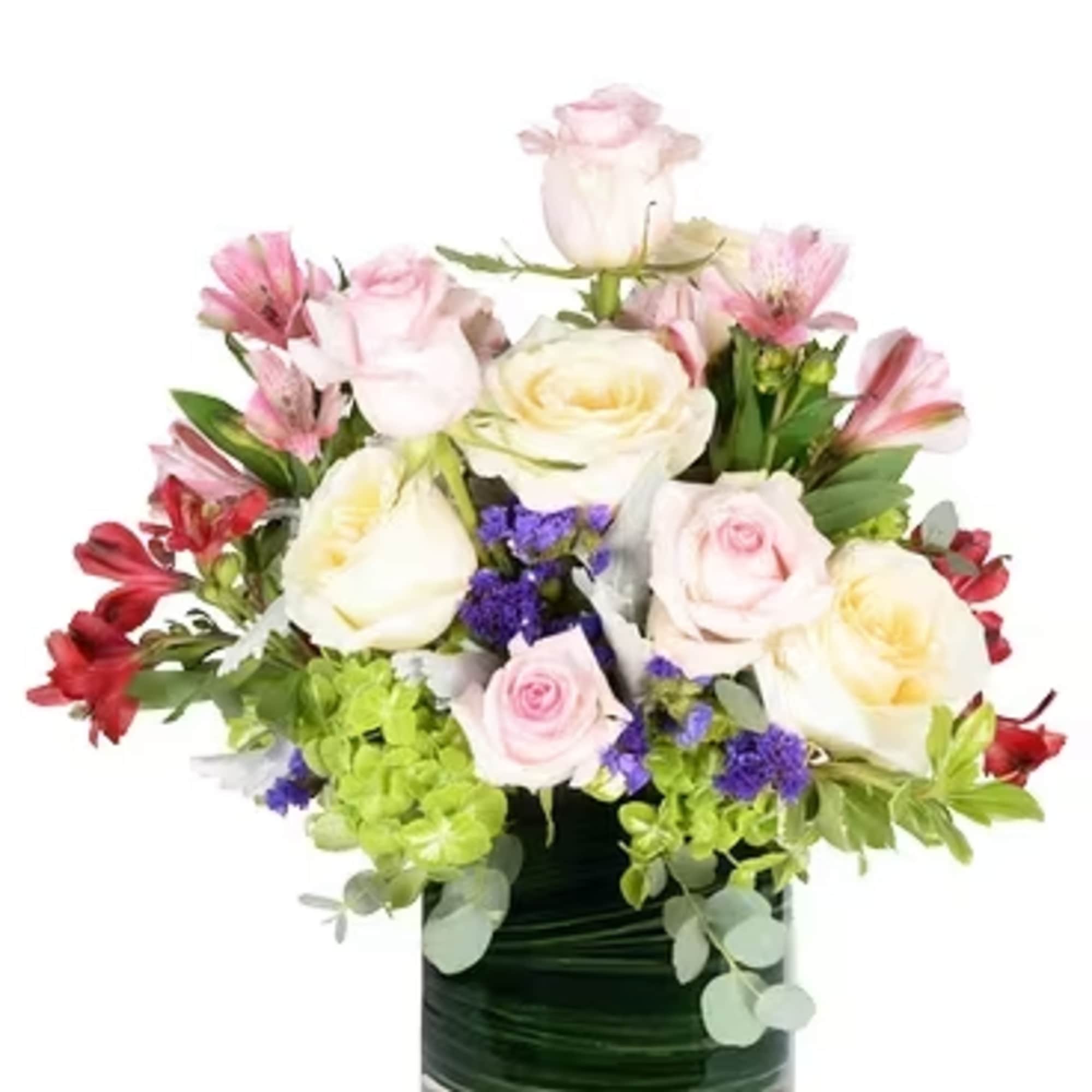 Mixed pink and white roses in a glass vase with purple accents