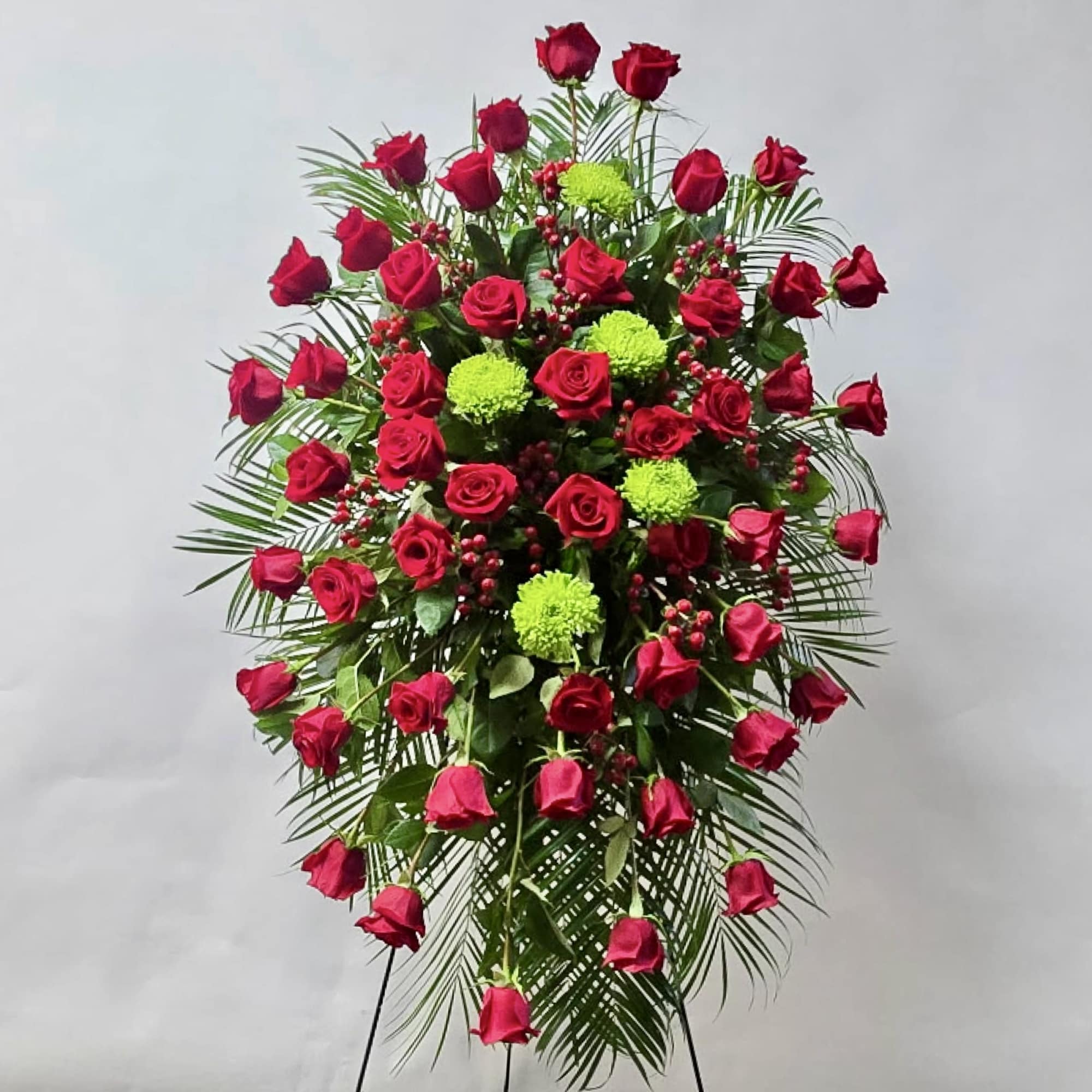 Standing spray of red roses with green pompons and palm fronds