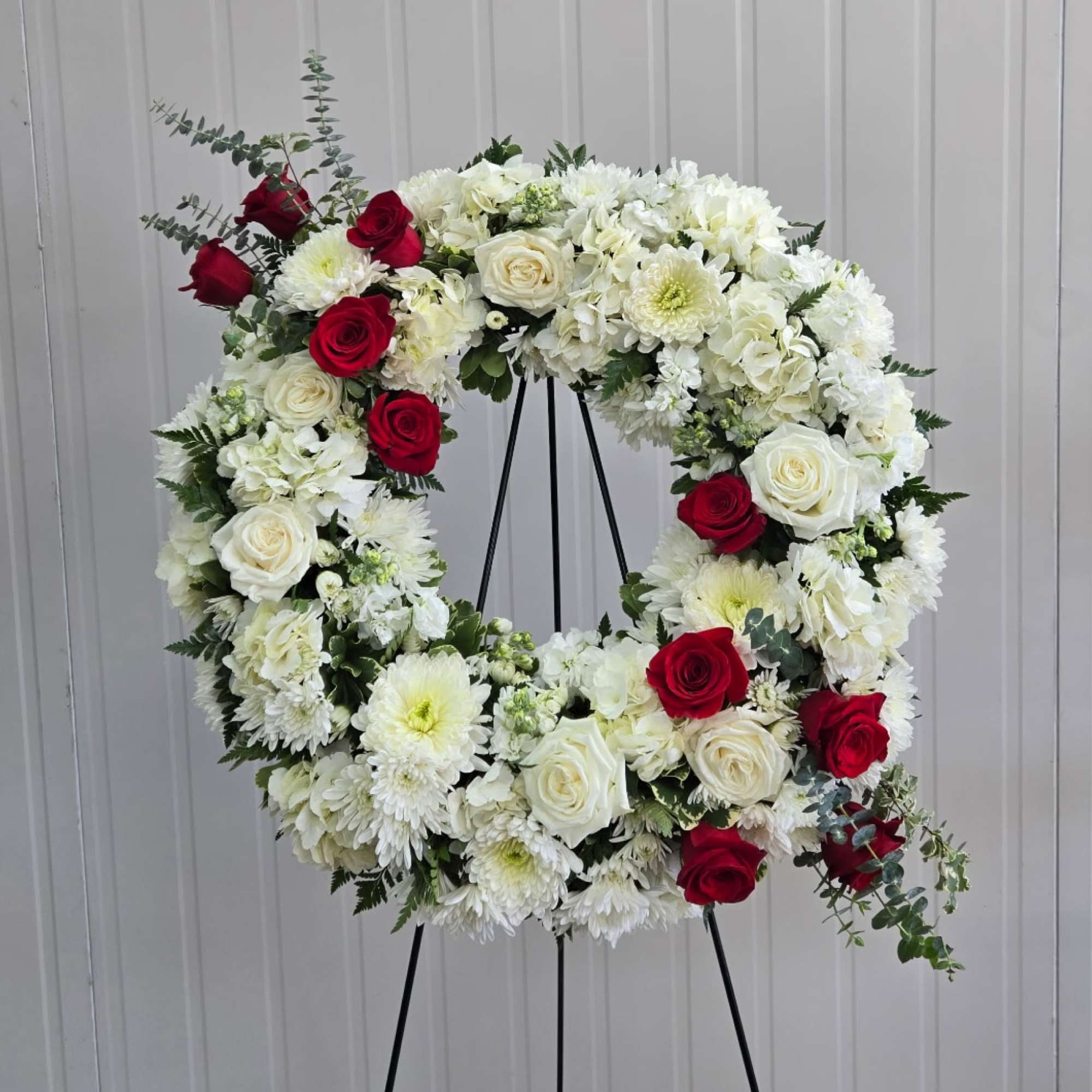 This 18" Wreath on an Easel includes, White Hydrangea, White Fuji Mums