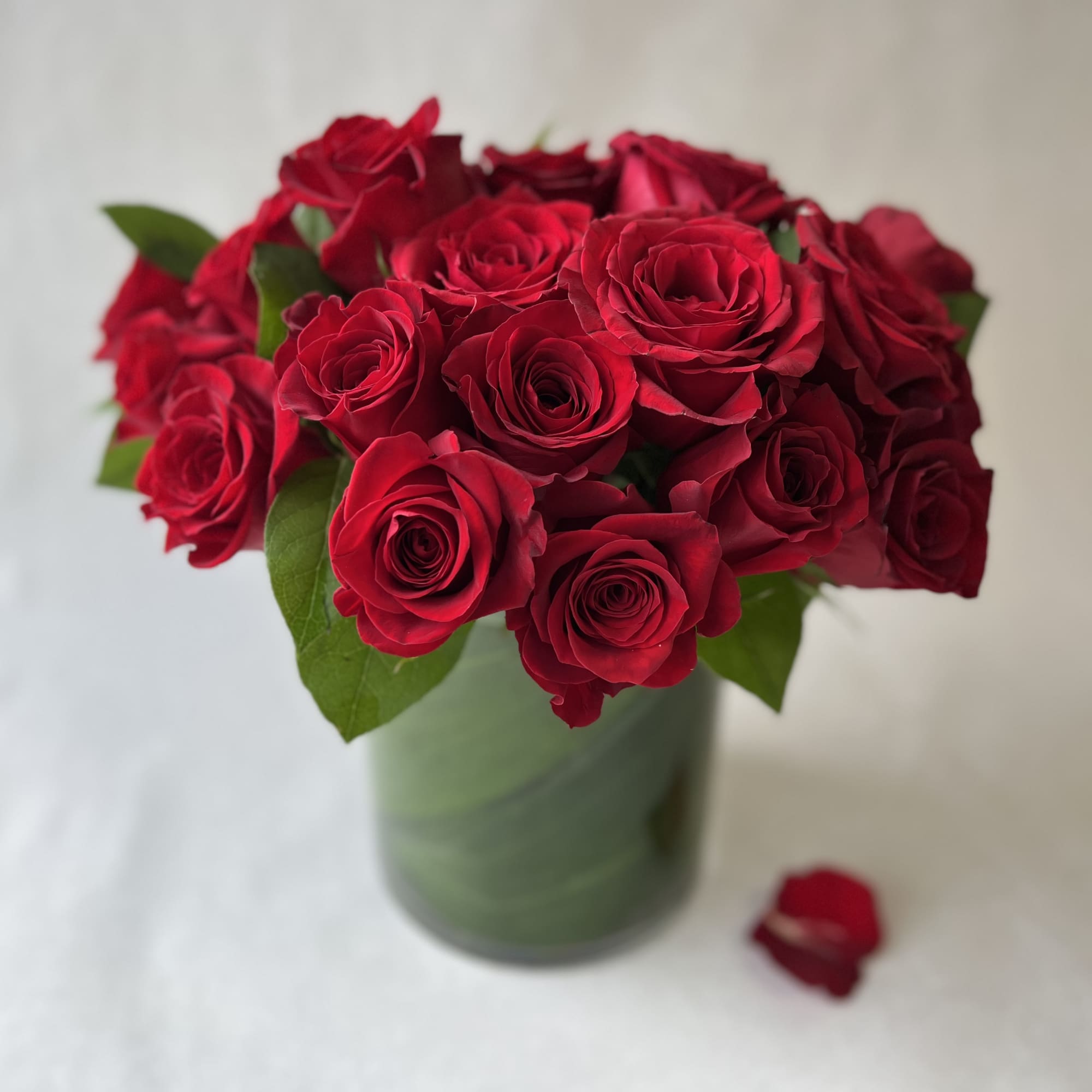 Bouquet of red roses in a green vase