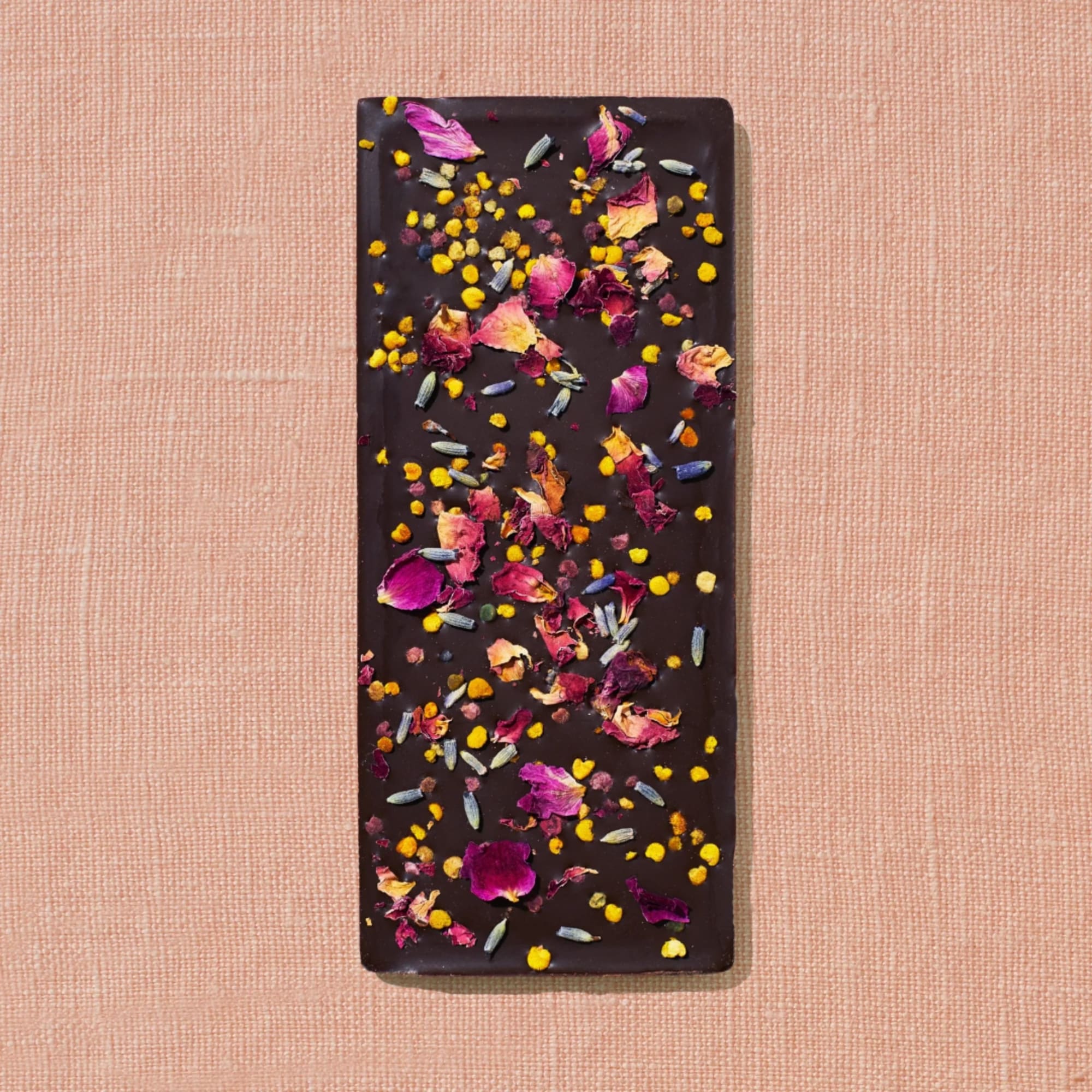 Dark chocolate bar topped with dried flower petals and colorful sprinkles
