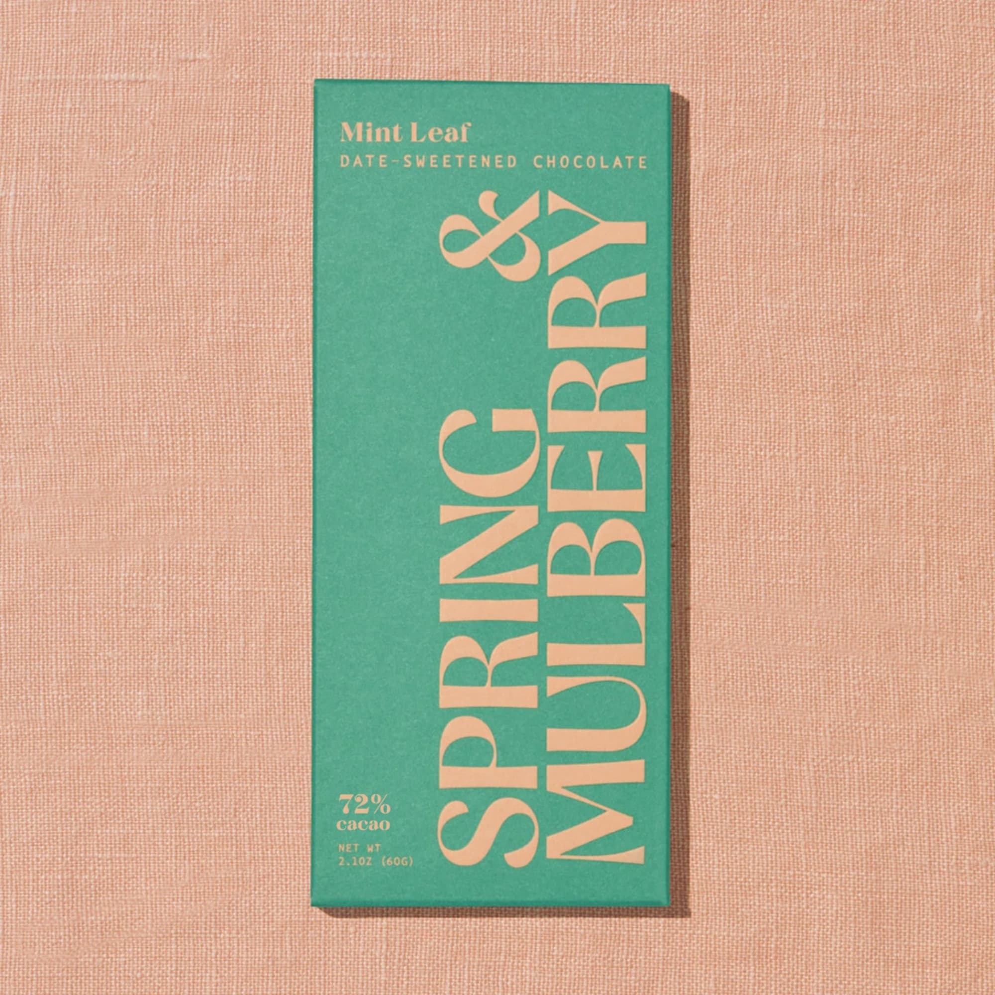 Green chocolate bar package on a pink textured background