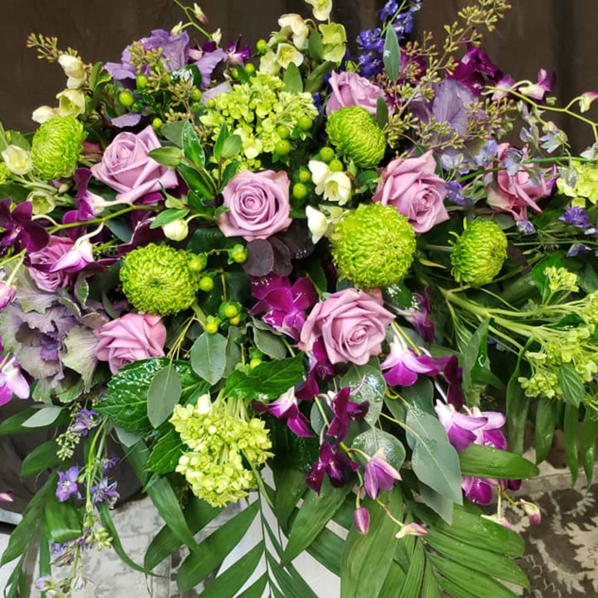 Large purple and green floral spray with roses and orchids