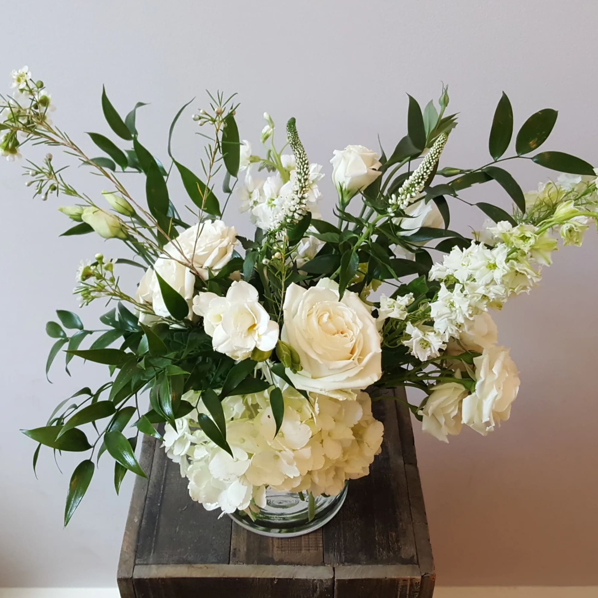 Elegant, soft, and full arrangement featuring larkspur, freesia, lisianthus, and other seasonal