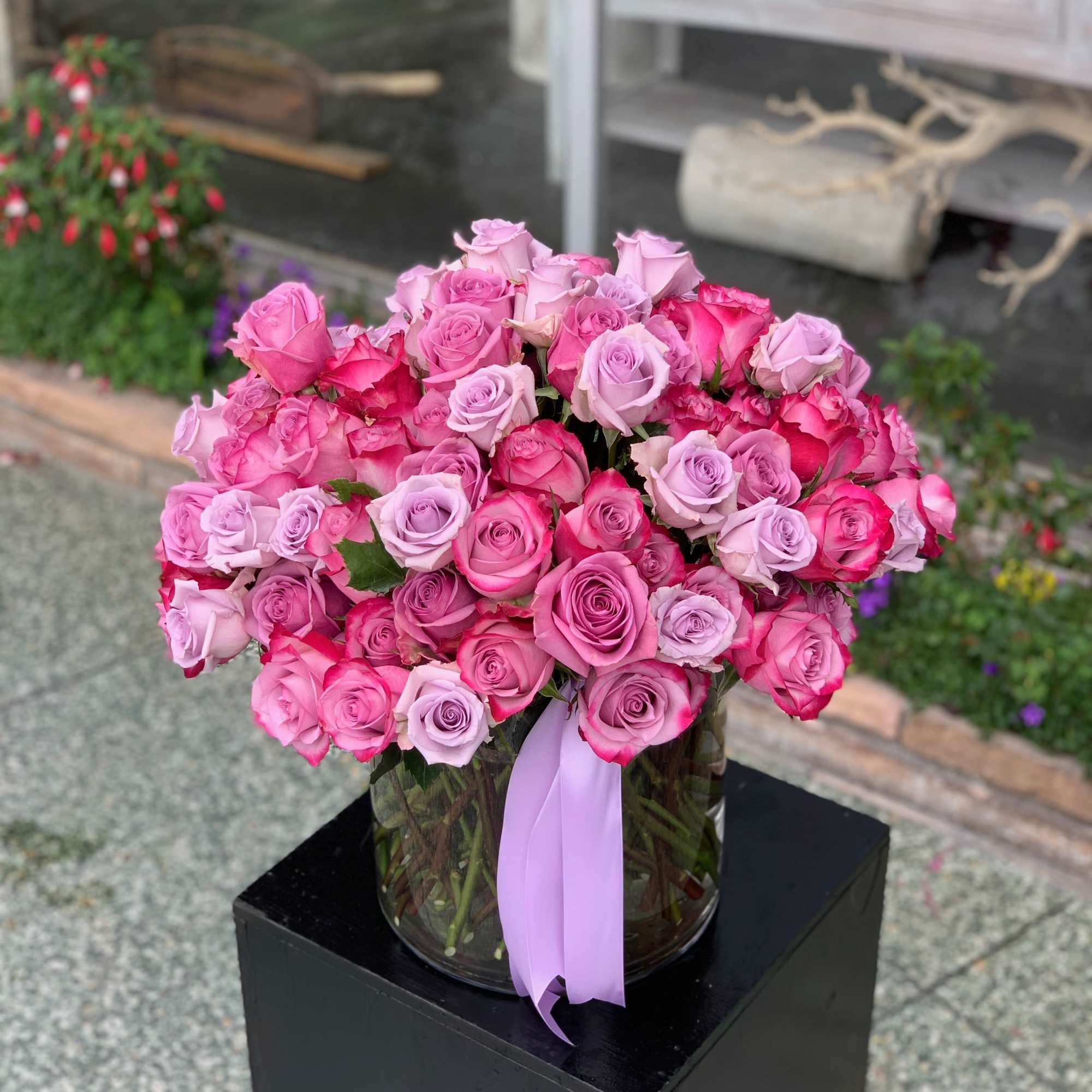 Bouquet of pink and lavender roses in a glass vase with a ribbon