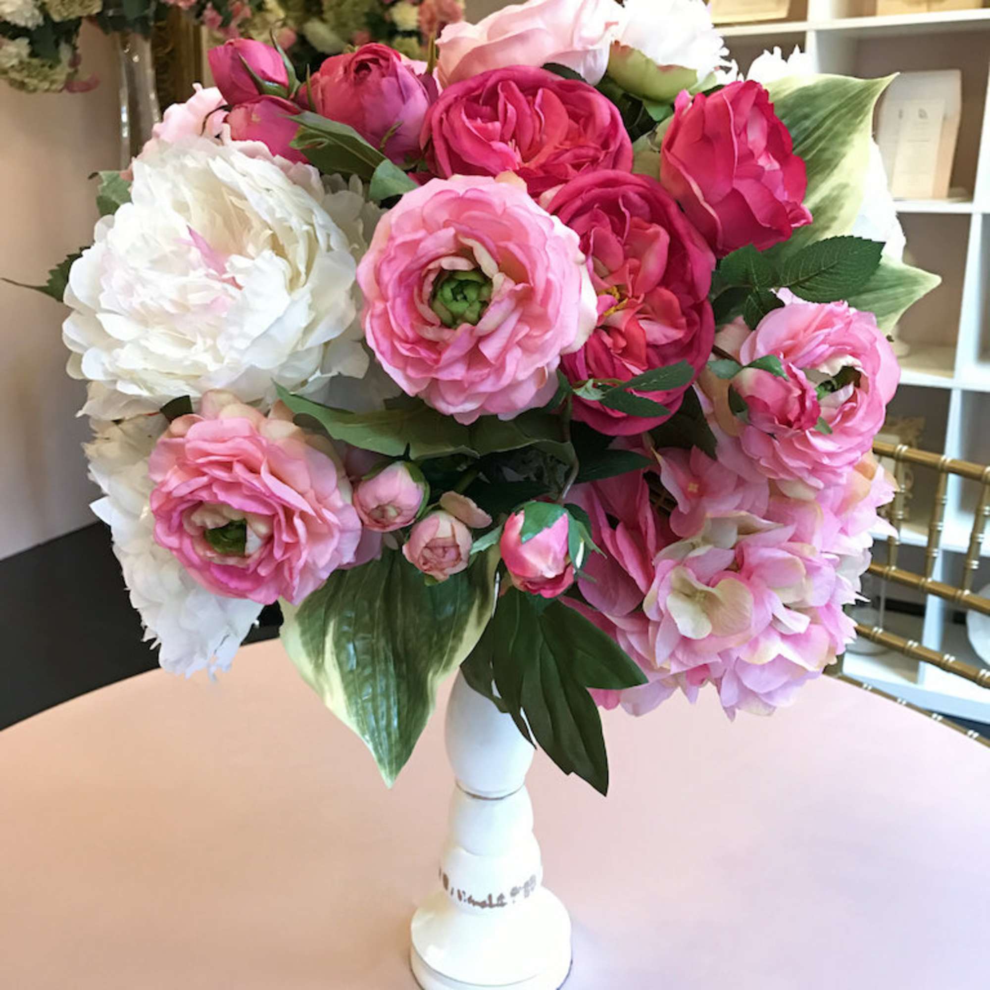 Pink and white peony bouquet in a white vase