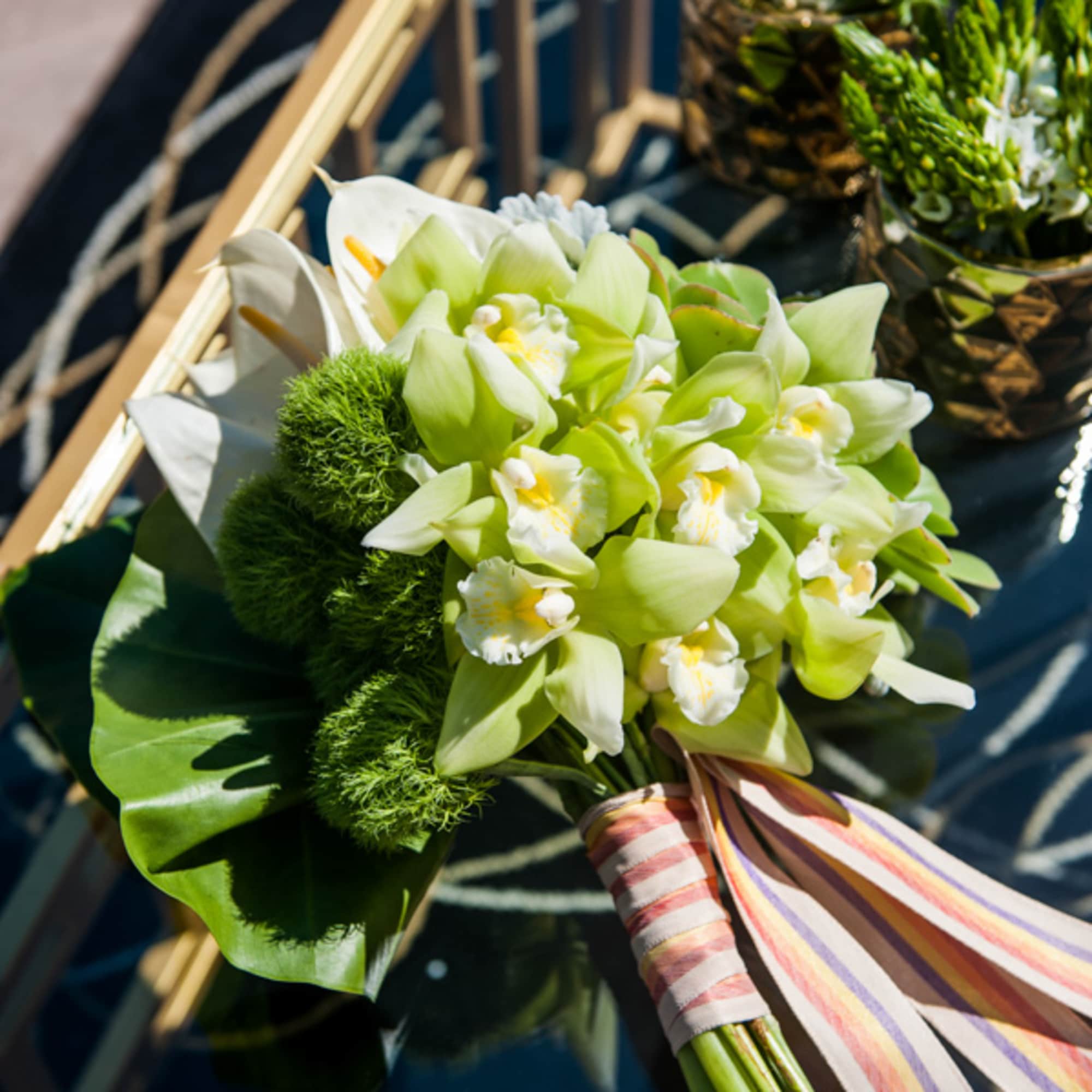 Bouquet of green orchids with white flowers and striped ribbon