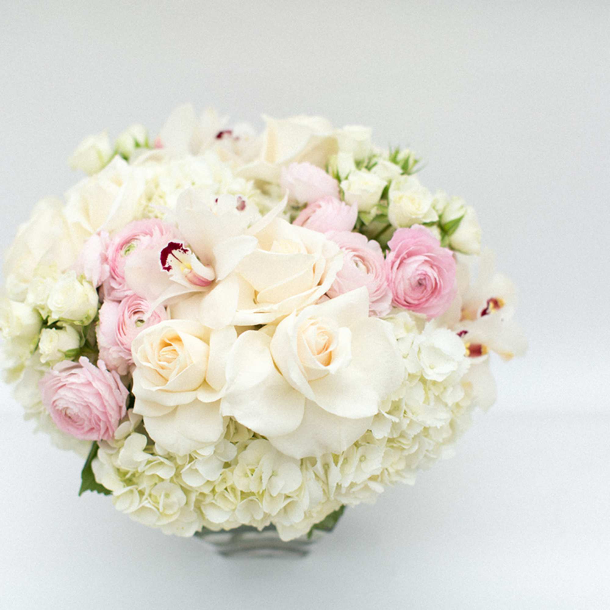 Round bouquet of white and pink flowers in a low vase