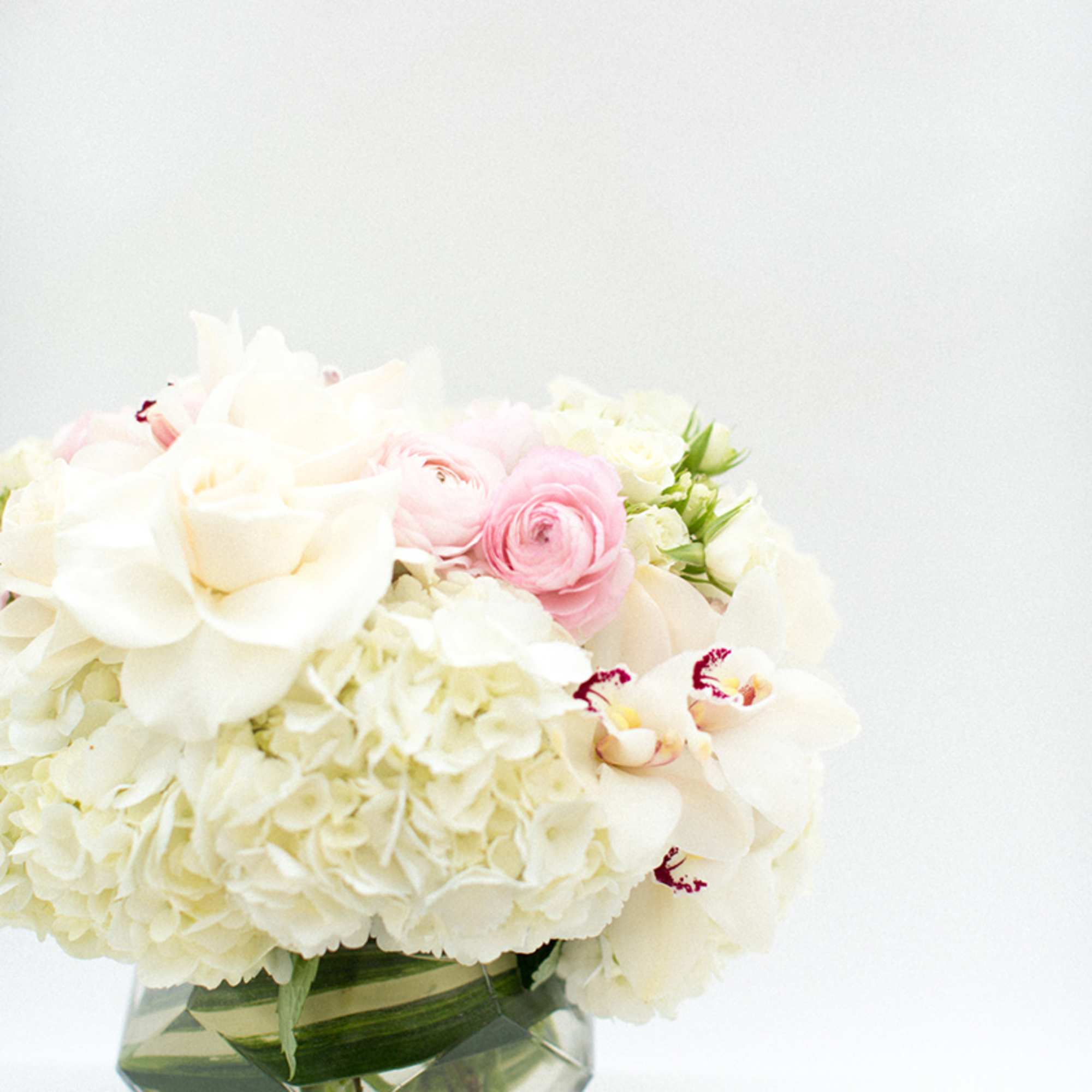 White and pink flowers arranged in a clear glass vase
