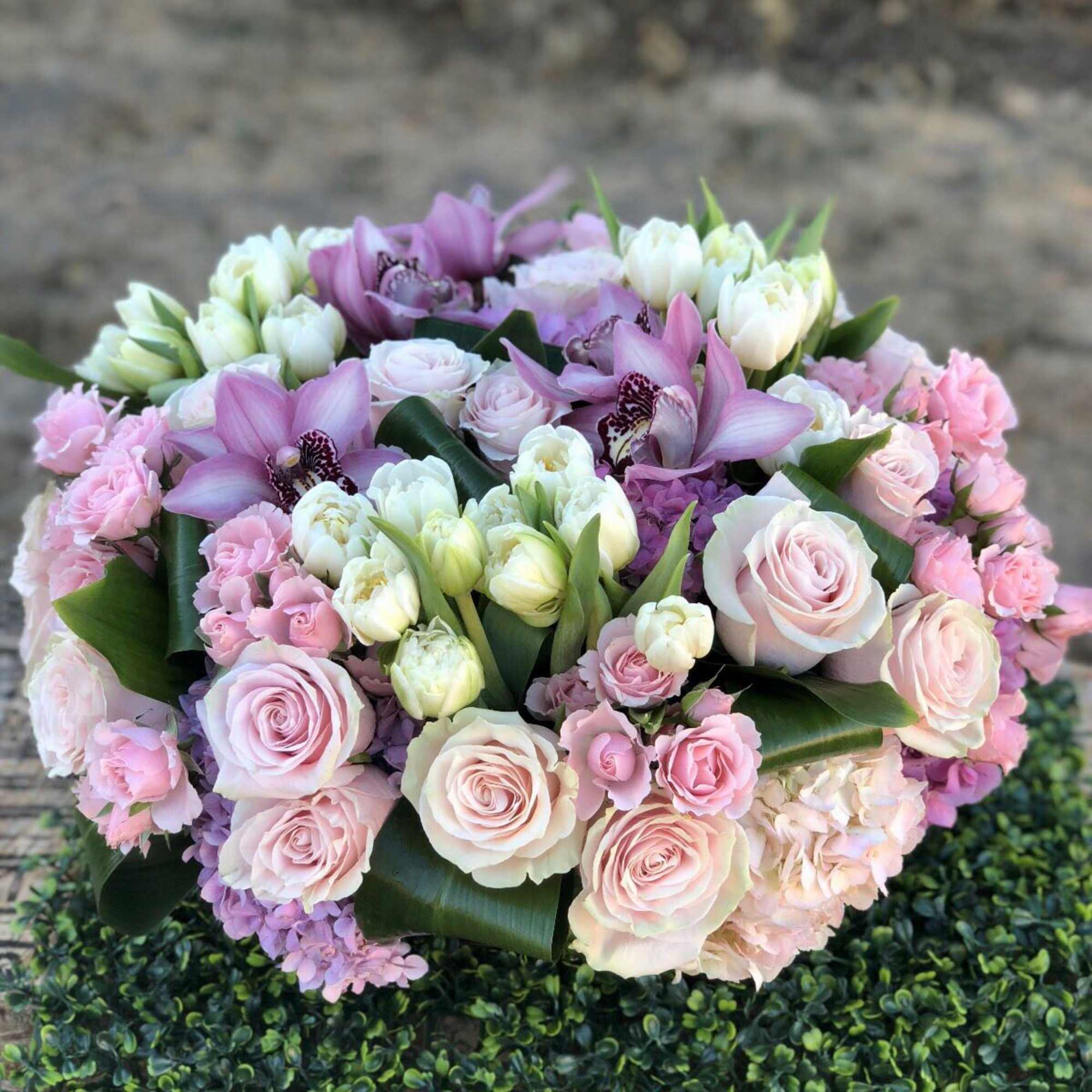 Pink and white bouquet with roses, tulips, and orchids