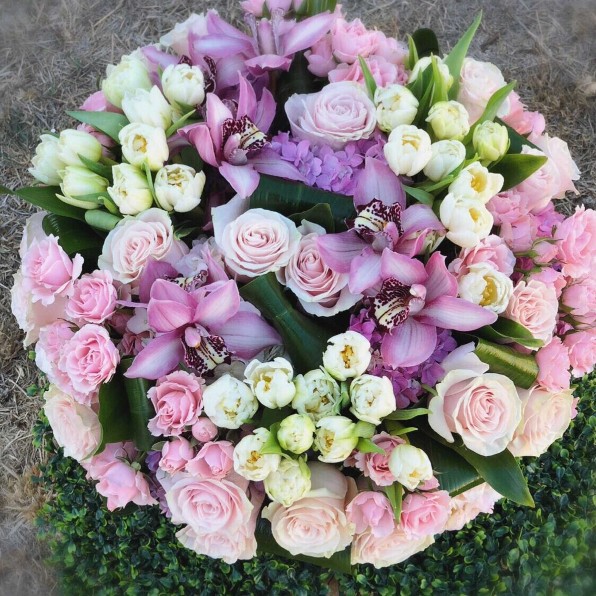 Round bouquet of pink roses, orchids, and white tulips