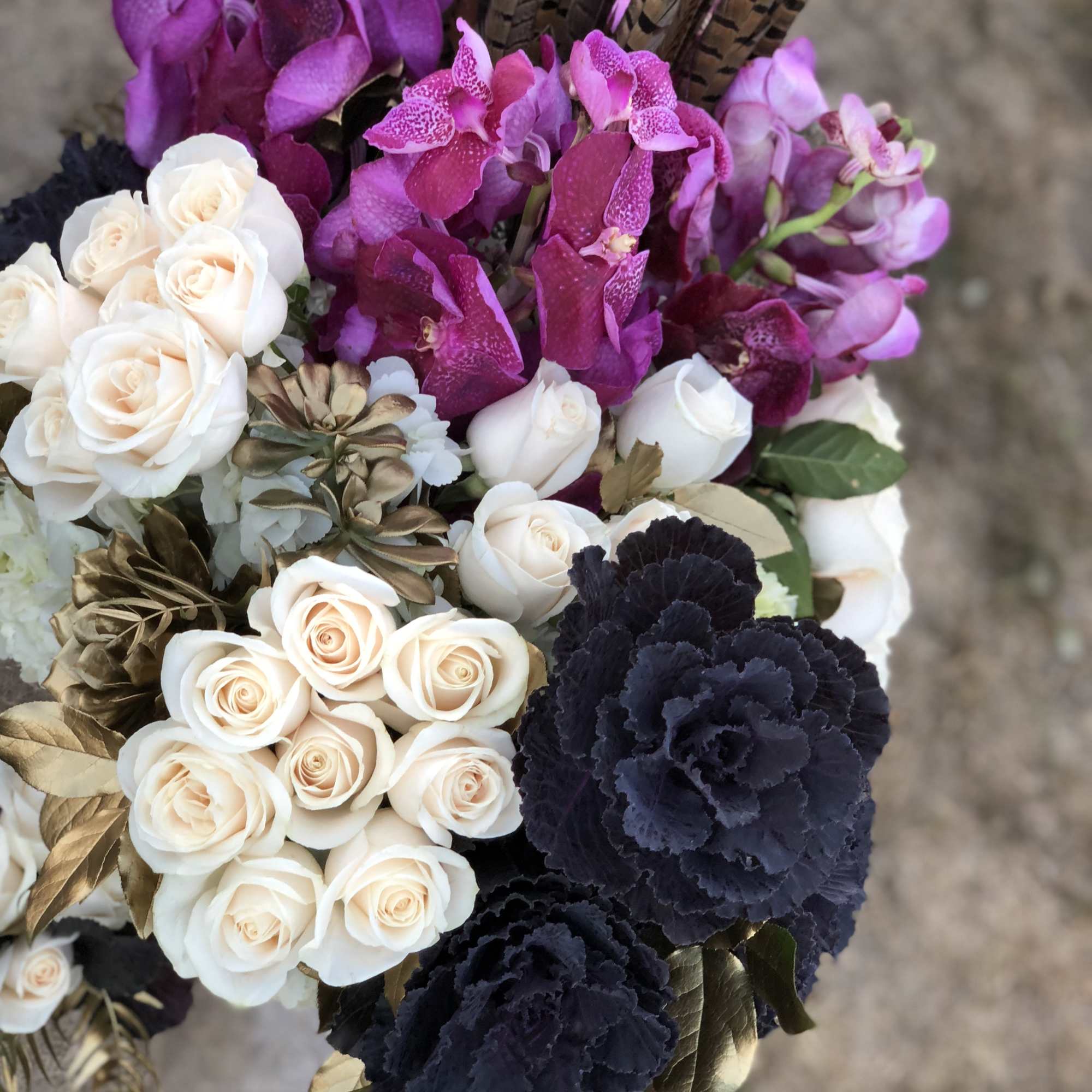 Bouquet of white roses, purple orchids, and dark carnations
