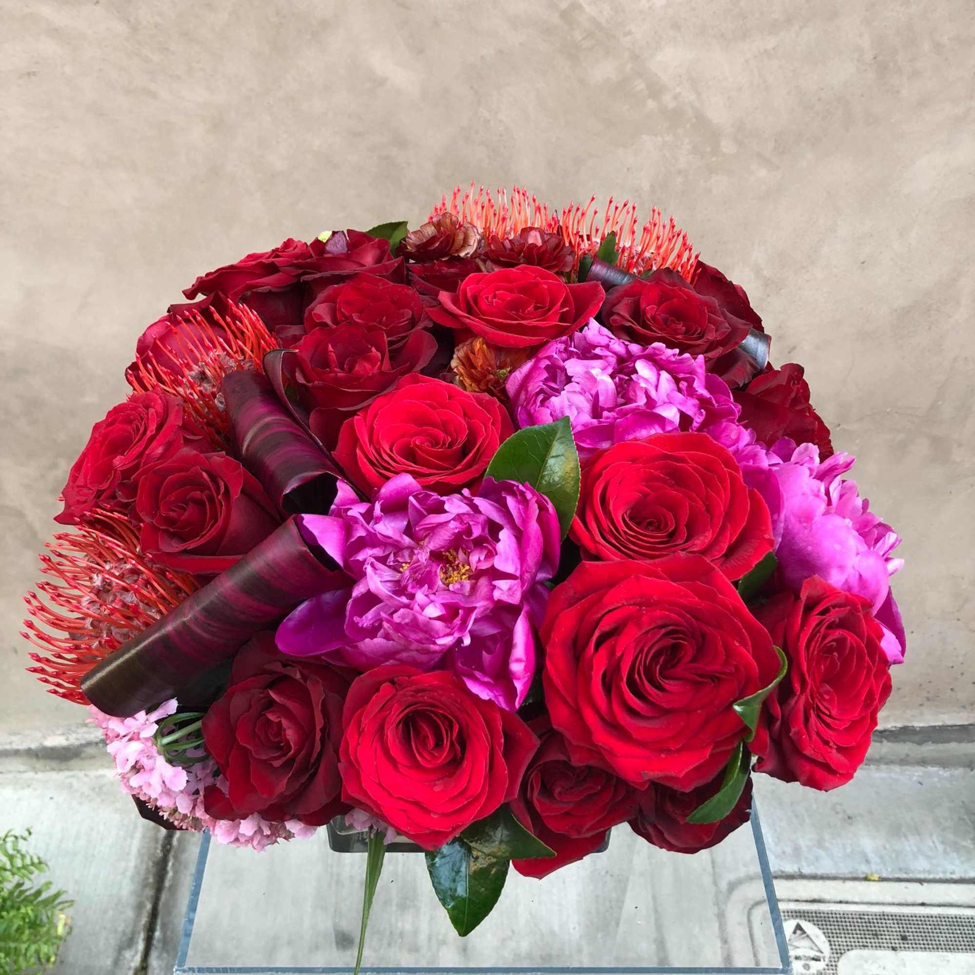Round bouquet of red roses and pink flowers