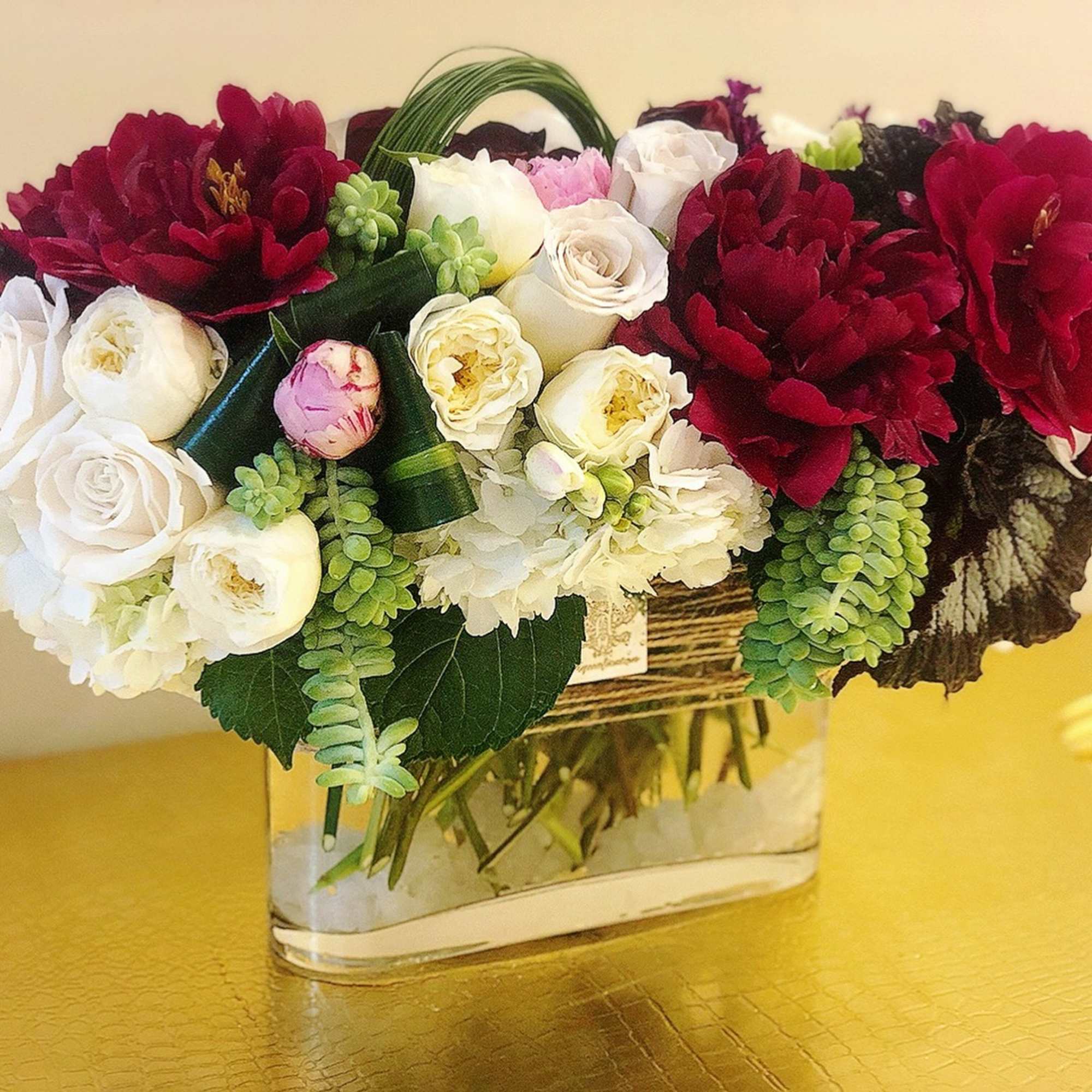Bouquet of red and white roses in a clear rectangular vase