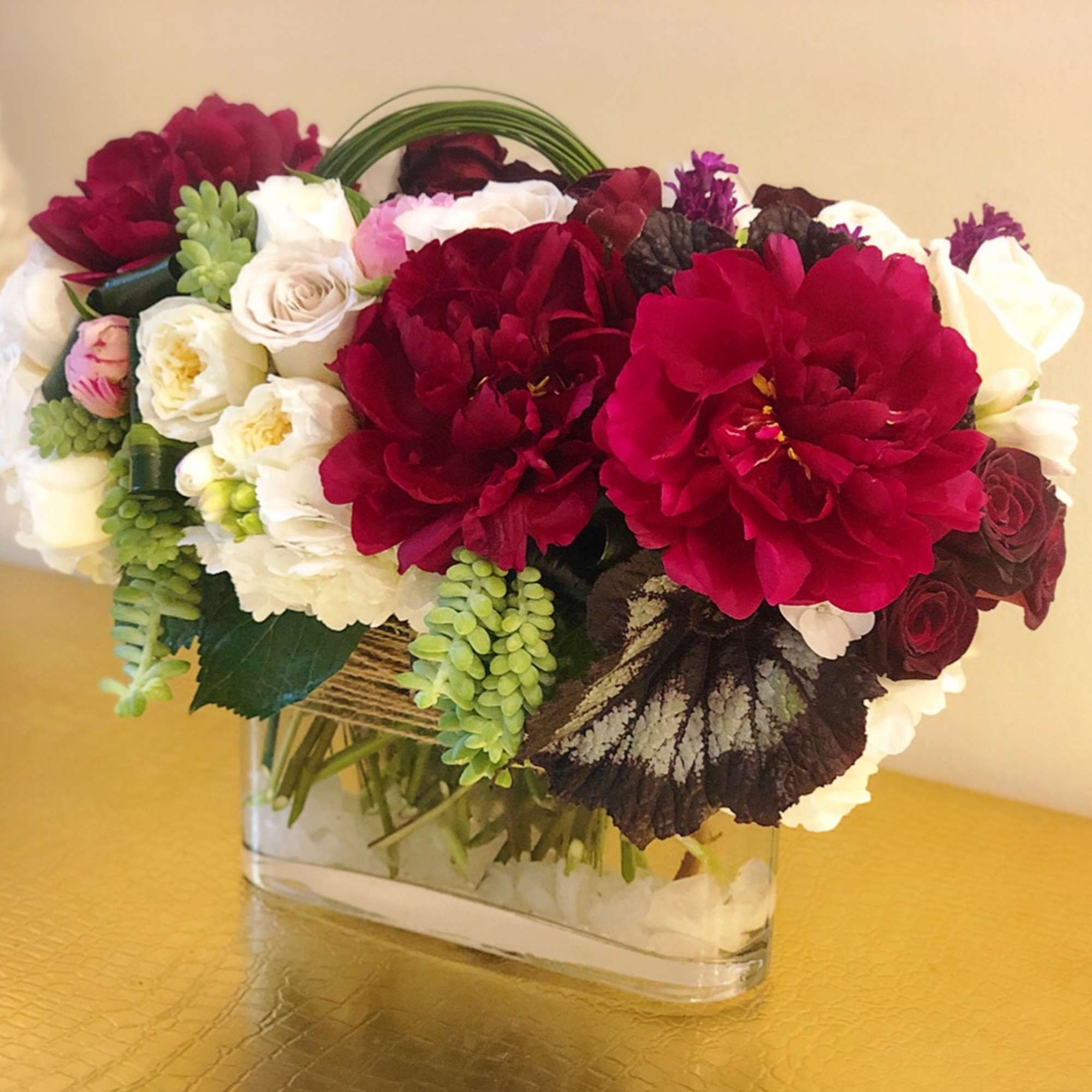 Bouquet of red, white, and pink flowers in a clear glass vase