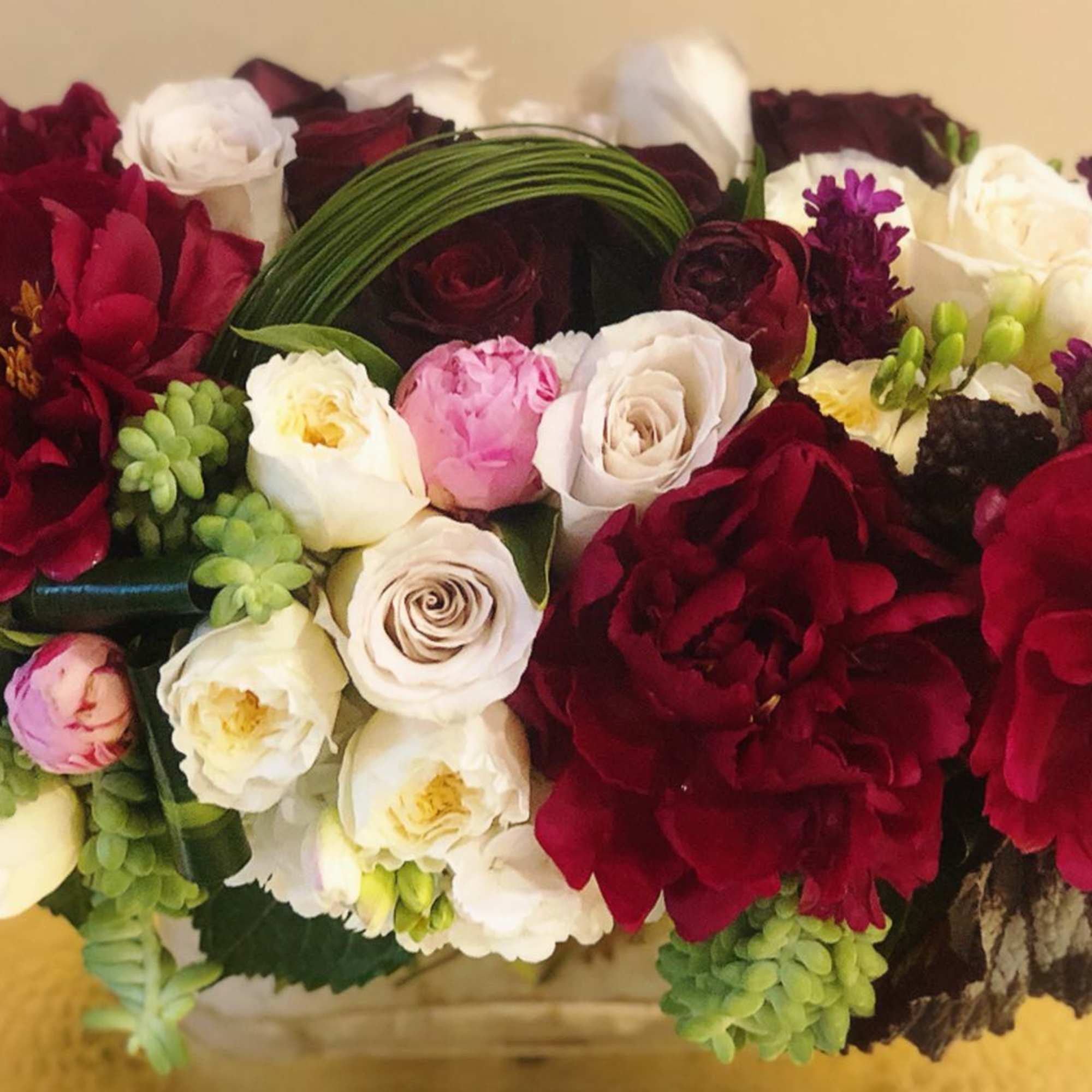 Bouquet of red, white, and pink roses with green accents