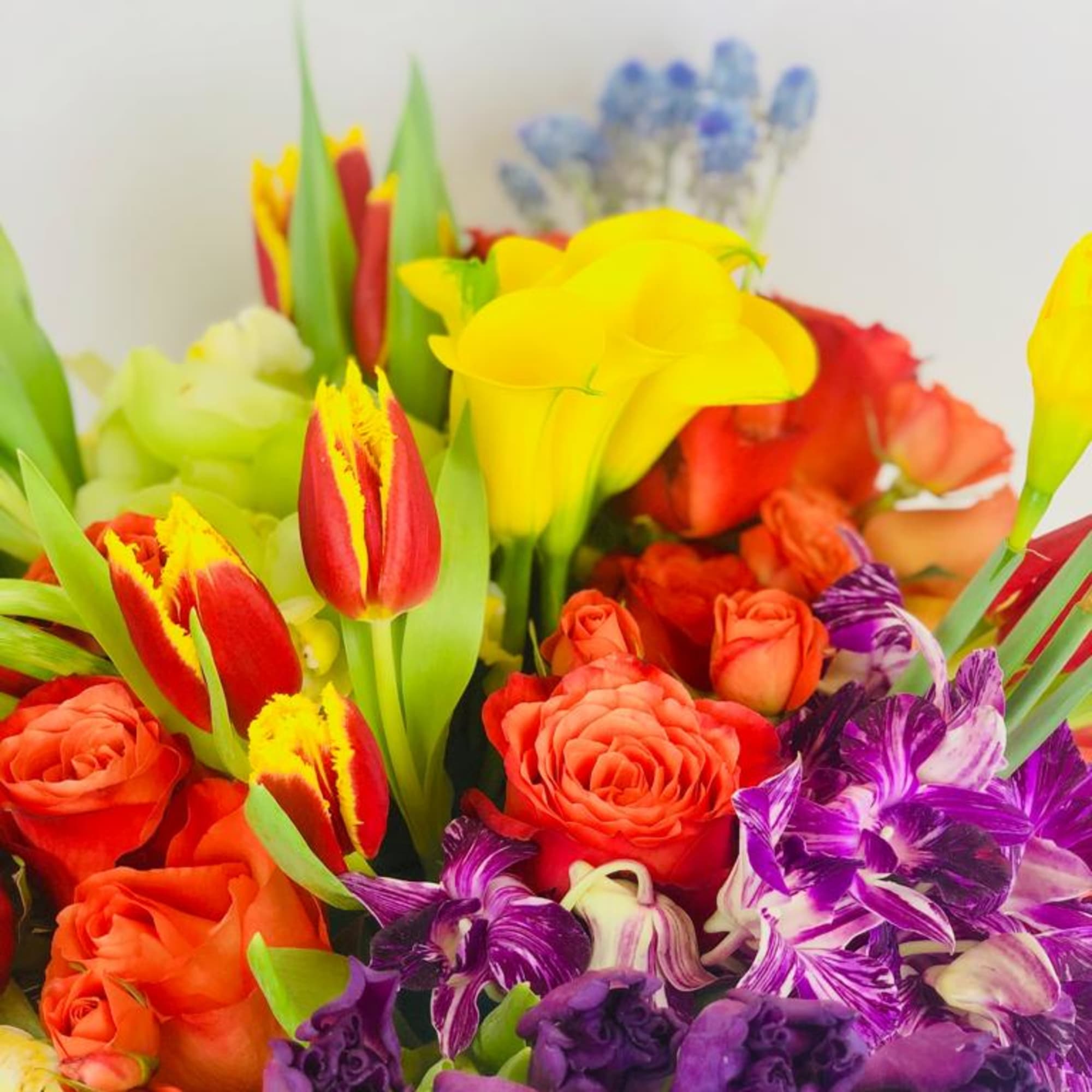 Colorful bouquet with roses, tulips, calla lilies, and purple orchids