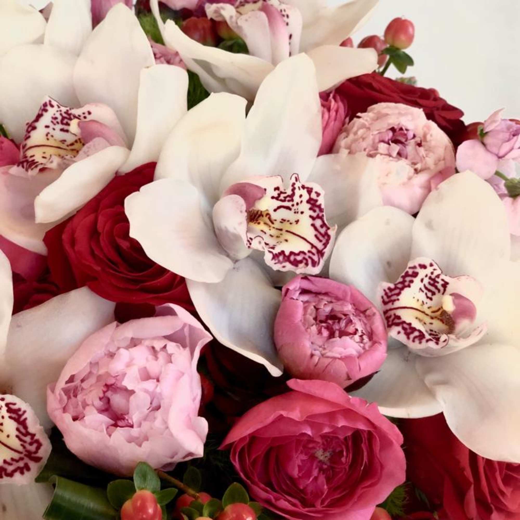 Bouquet of pink and red flowers with white orchids