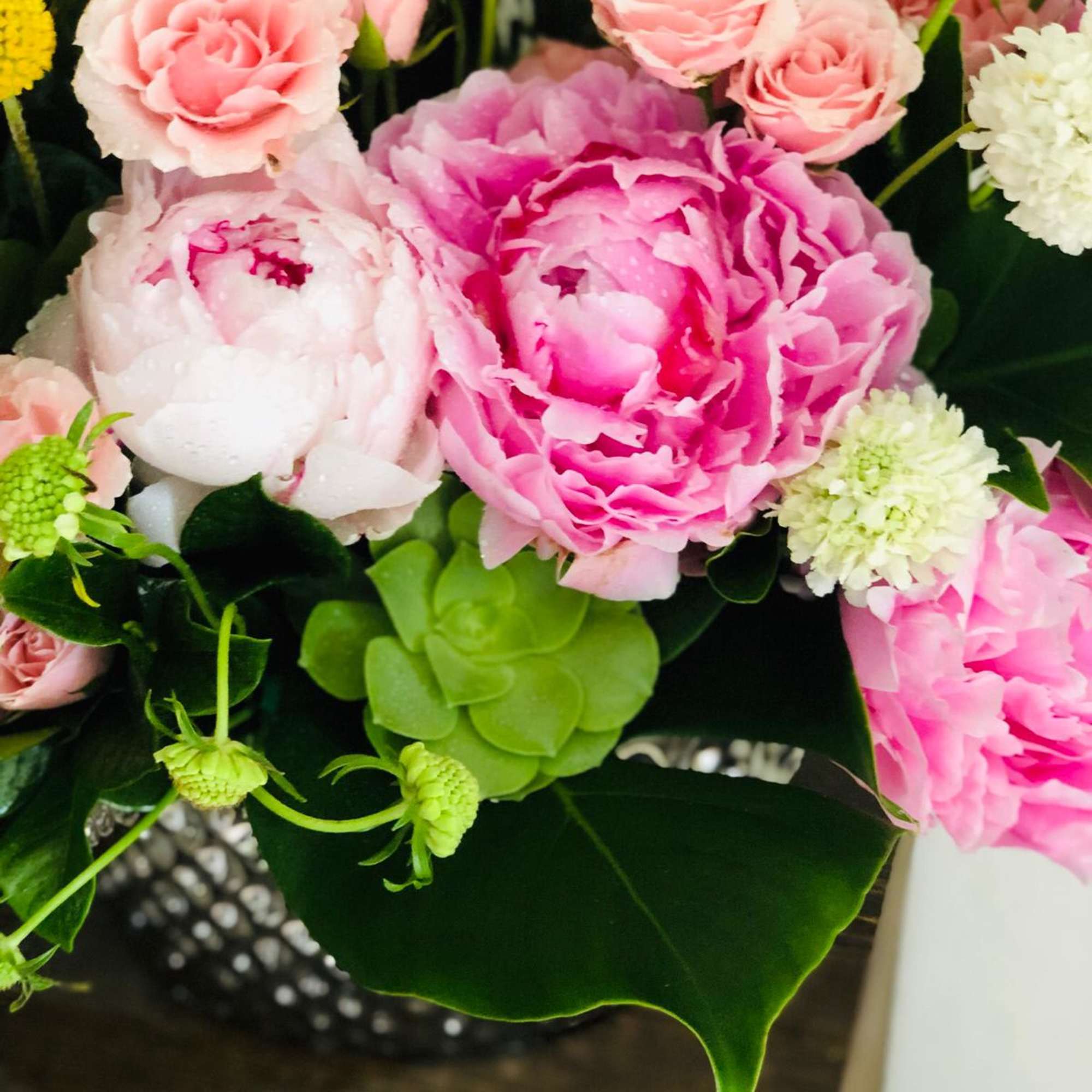 Pink peonies and small pink roses in a bouquet