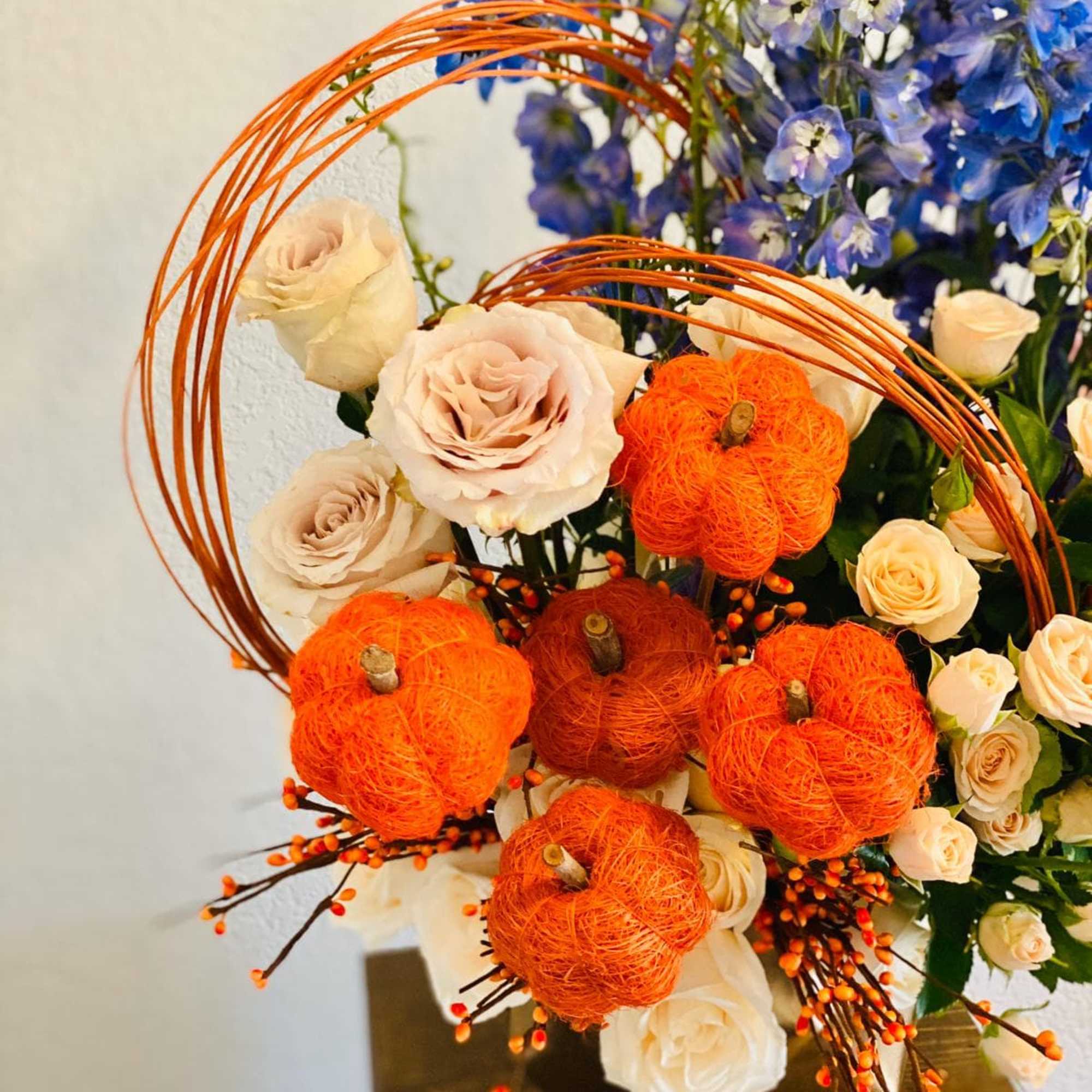 Bouquet of cream roses with blue flowers and orange pumpkin accents