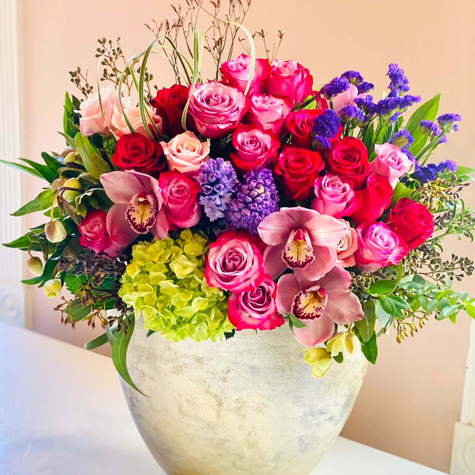 Mixed pink and purple floral arrangement in a silver vase