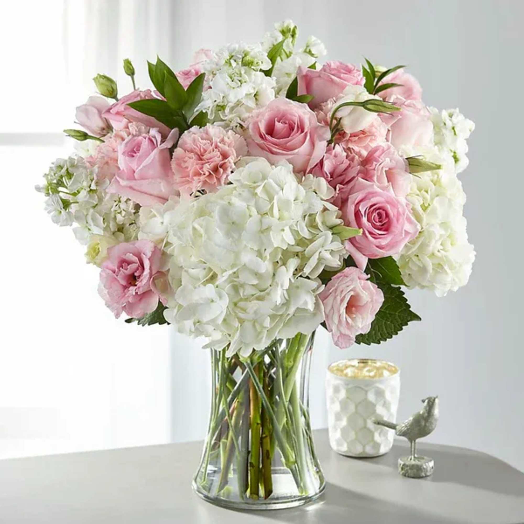 Pink roses and white hydrangeas in a clear glass vase
