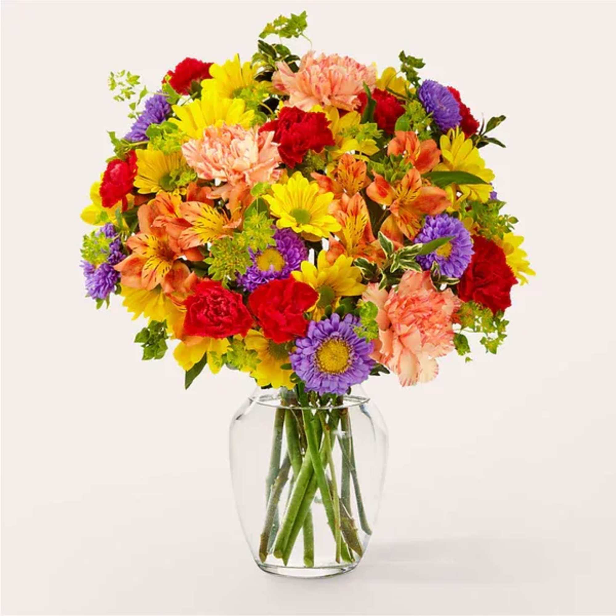 Mixed bouquet of colorful flowers in a clear glass vase