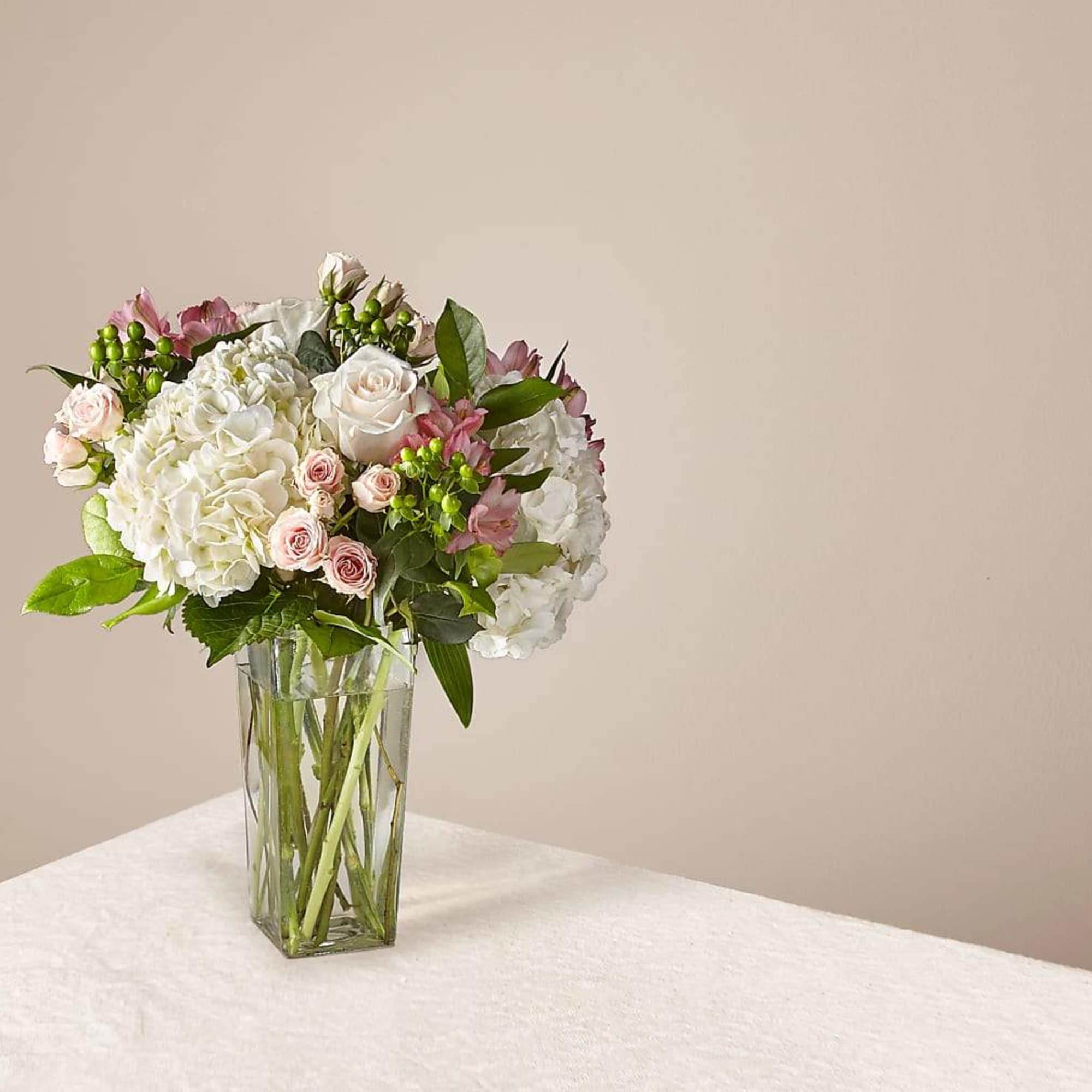 White and pink flower arrangement in a clear glass vase