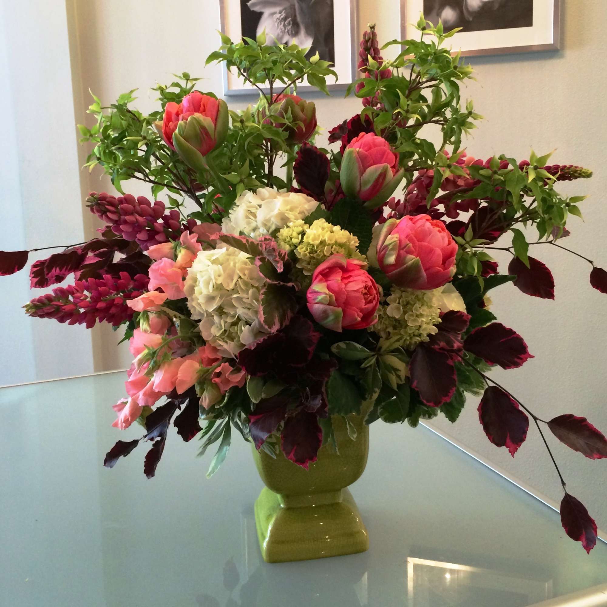 Mixed floral arrangement in a green vase with pink and white blooms