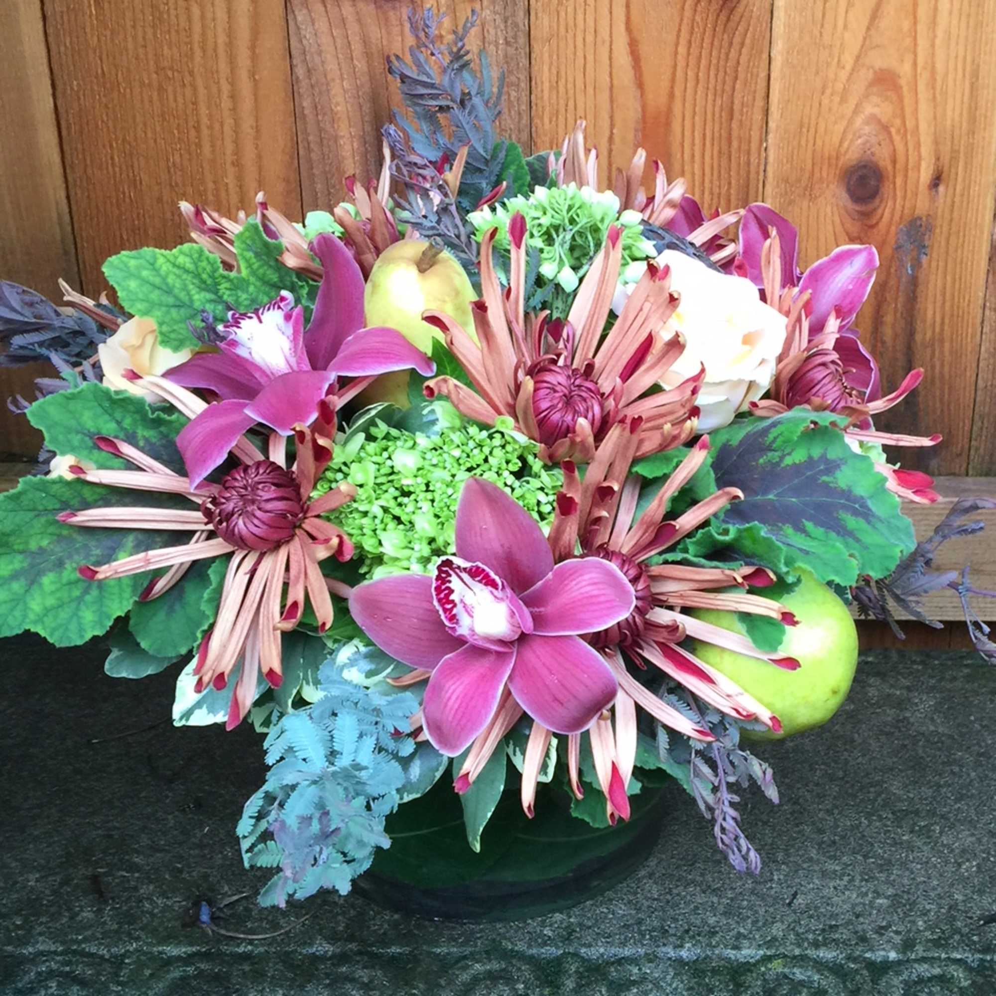 Mixed bouquet with pink orchids and chrysanthemums in a low vase