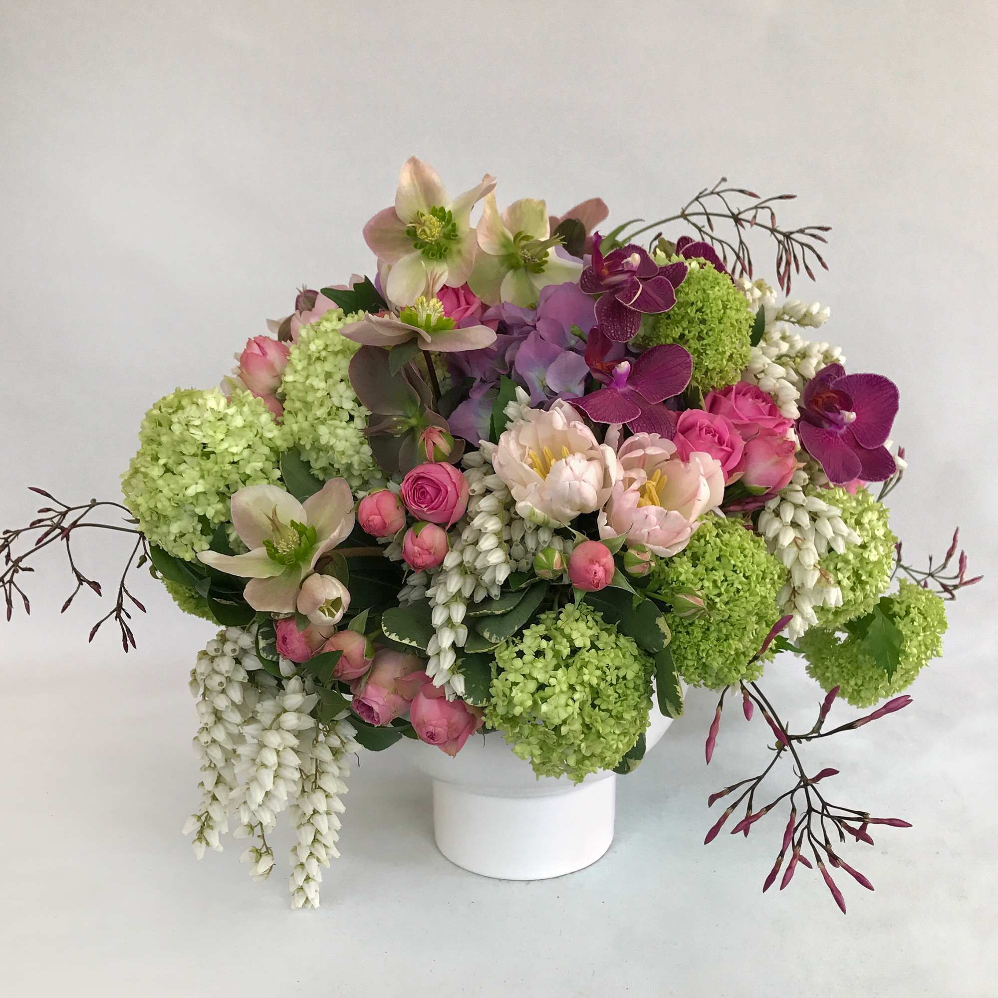 Mixed bouquet in a white vase with pink, white, and green flowers