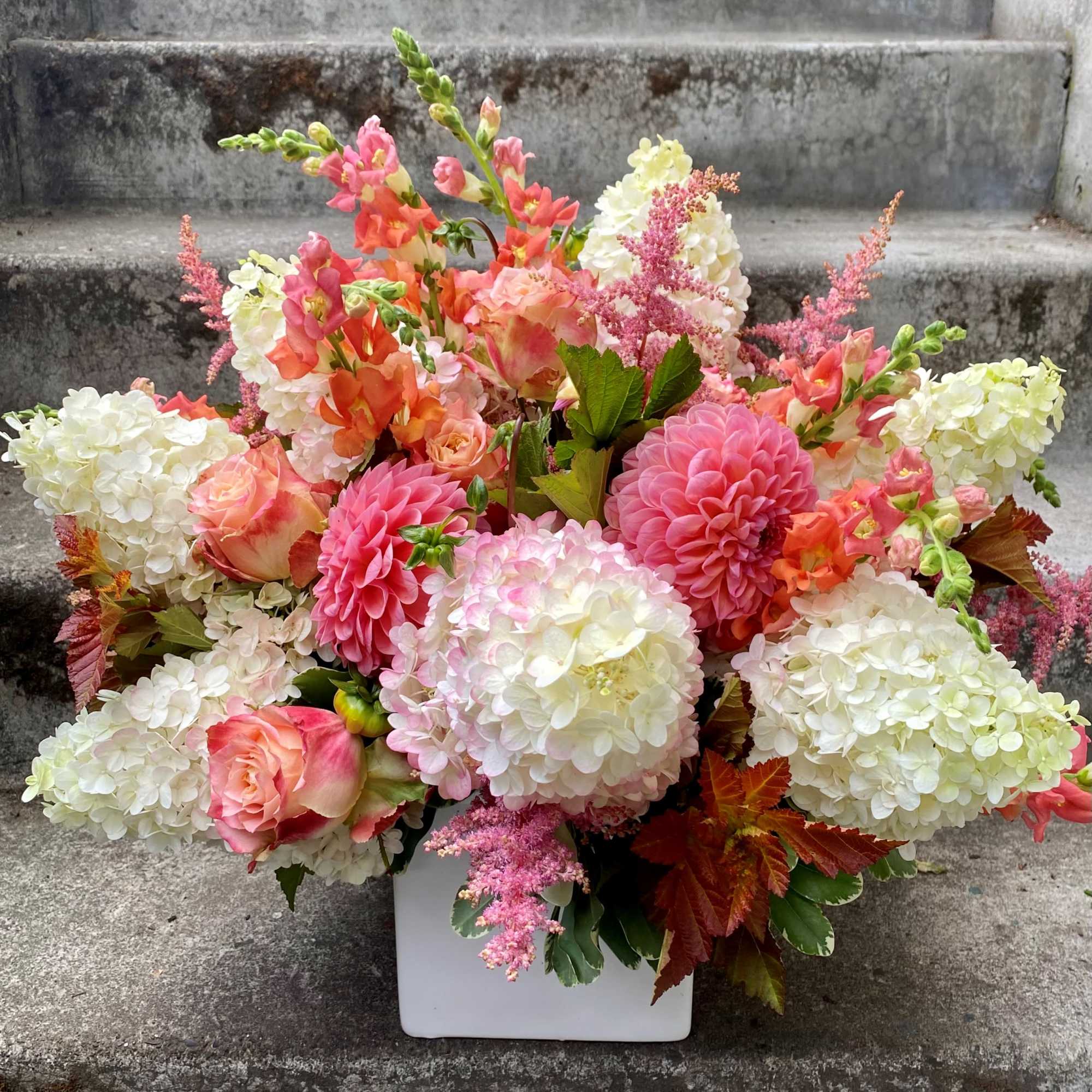 Pink and white floral arrangement in a white vase
