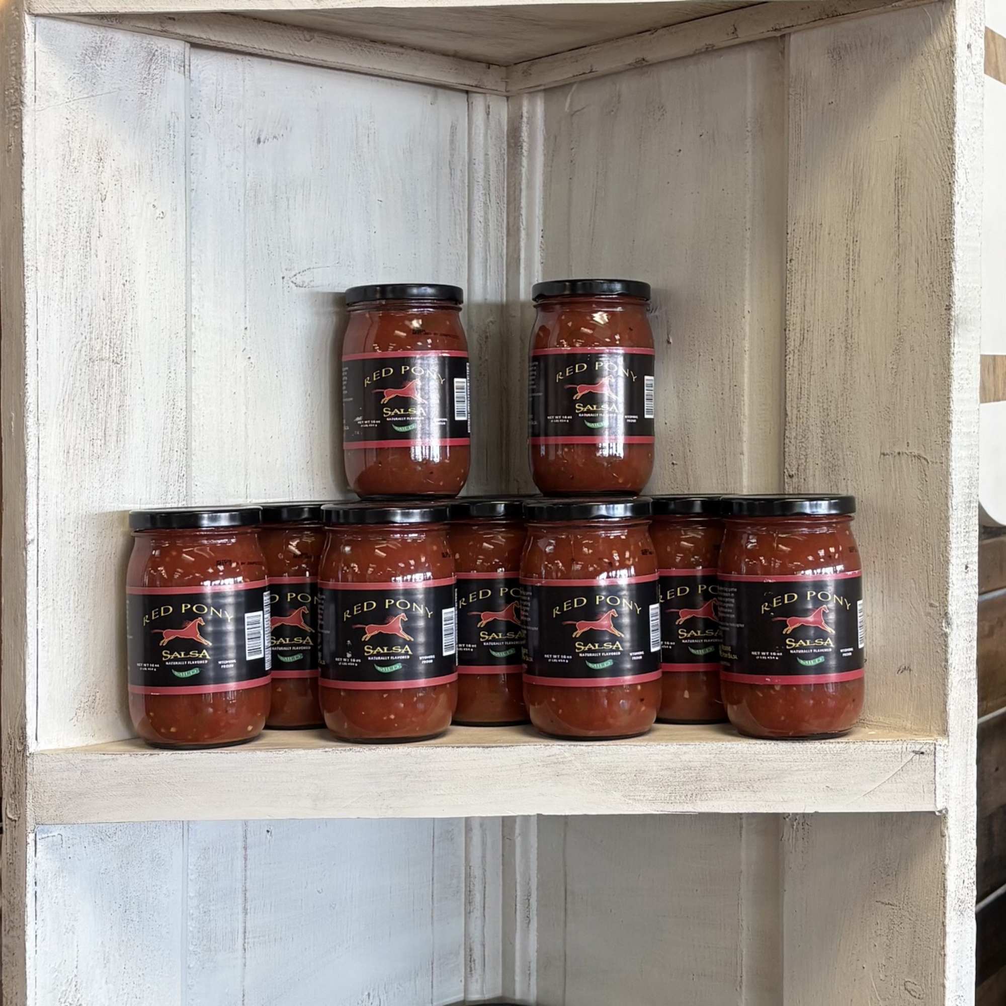 Shelves of Red Pony salsa and candied jalapeño relish jars