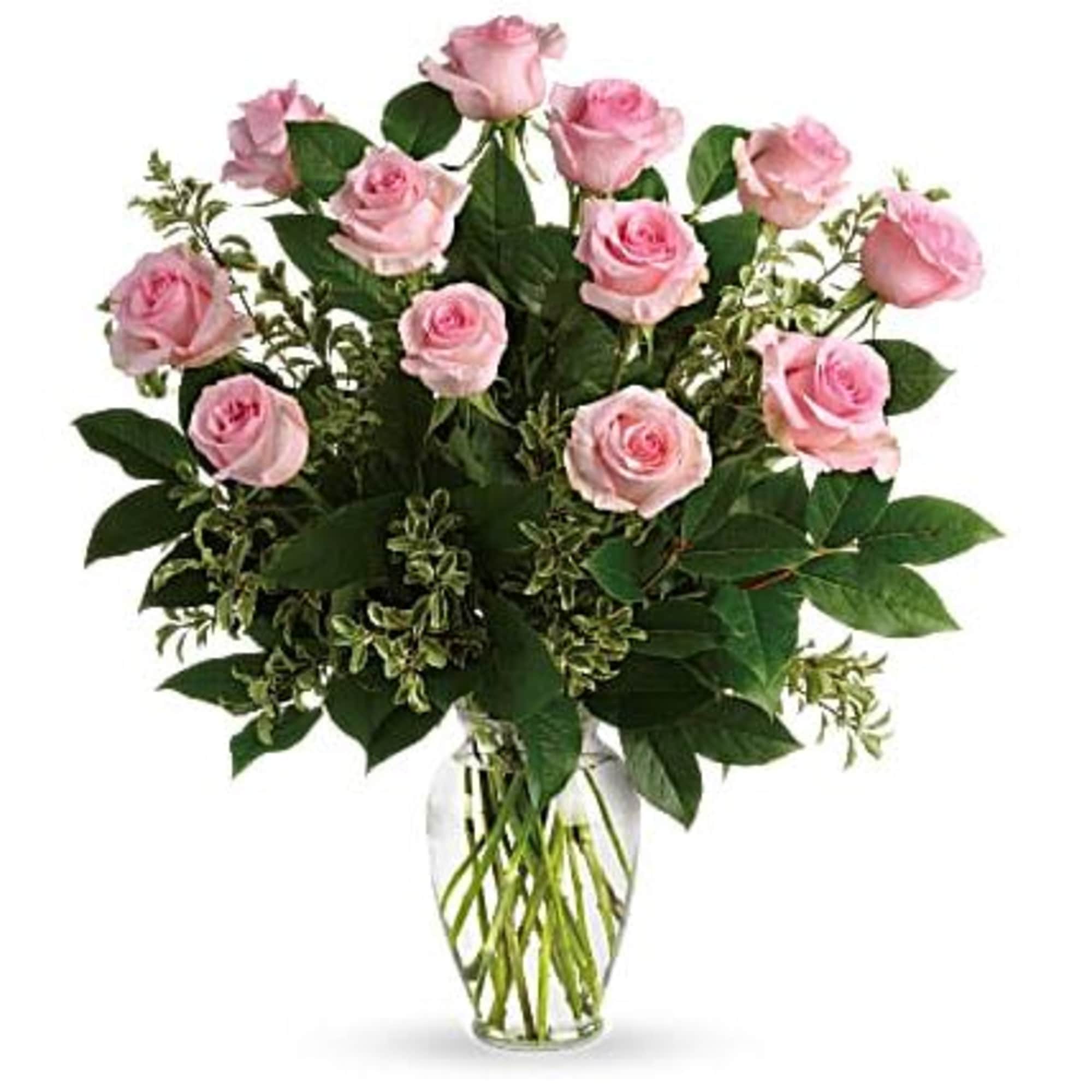 Arrangement of light pink roses with lush foliage in a clear glass vase