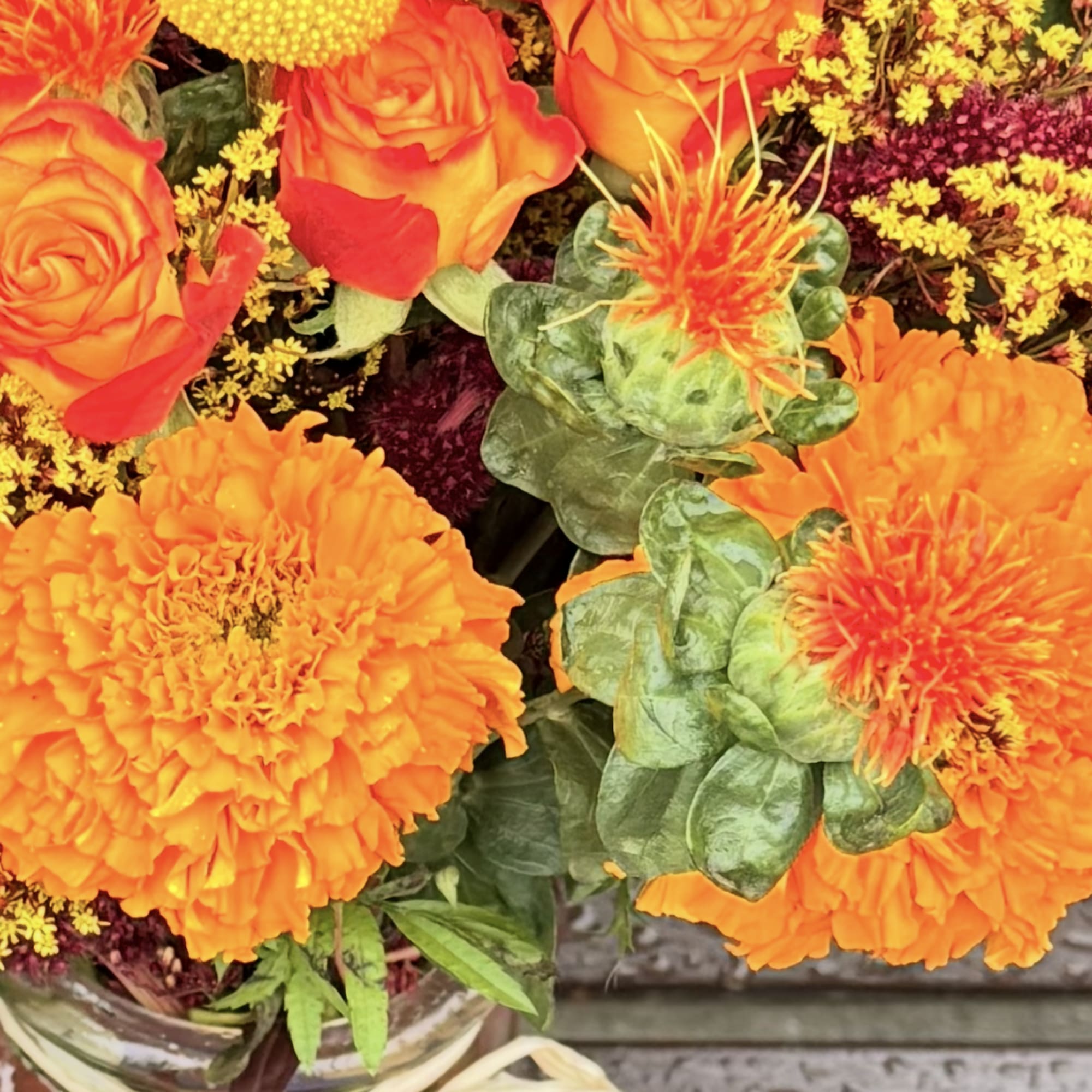 Orange and yellow flower arrangement in a glass vase