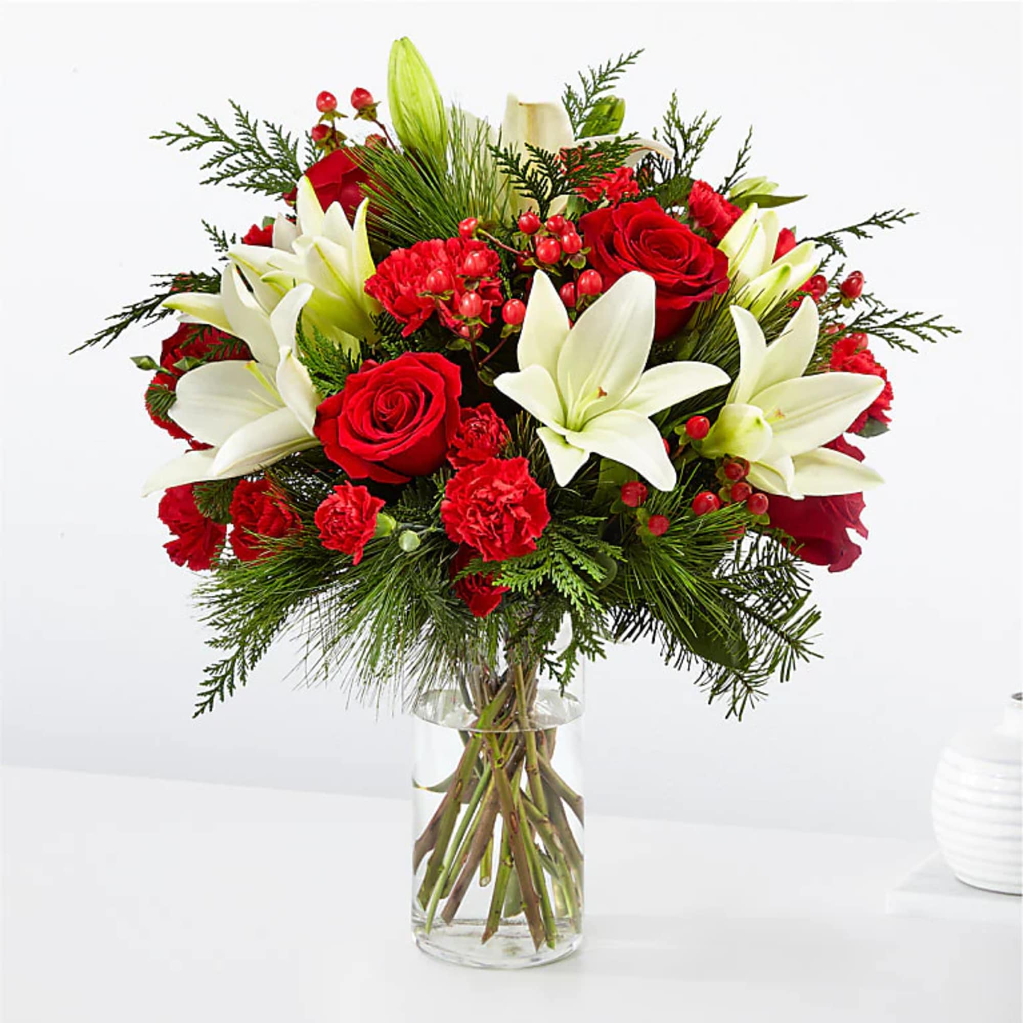 Bouquet of red roses and white lilies in a clear glass vase