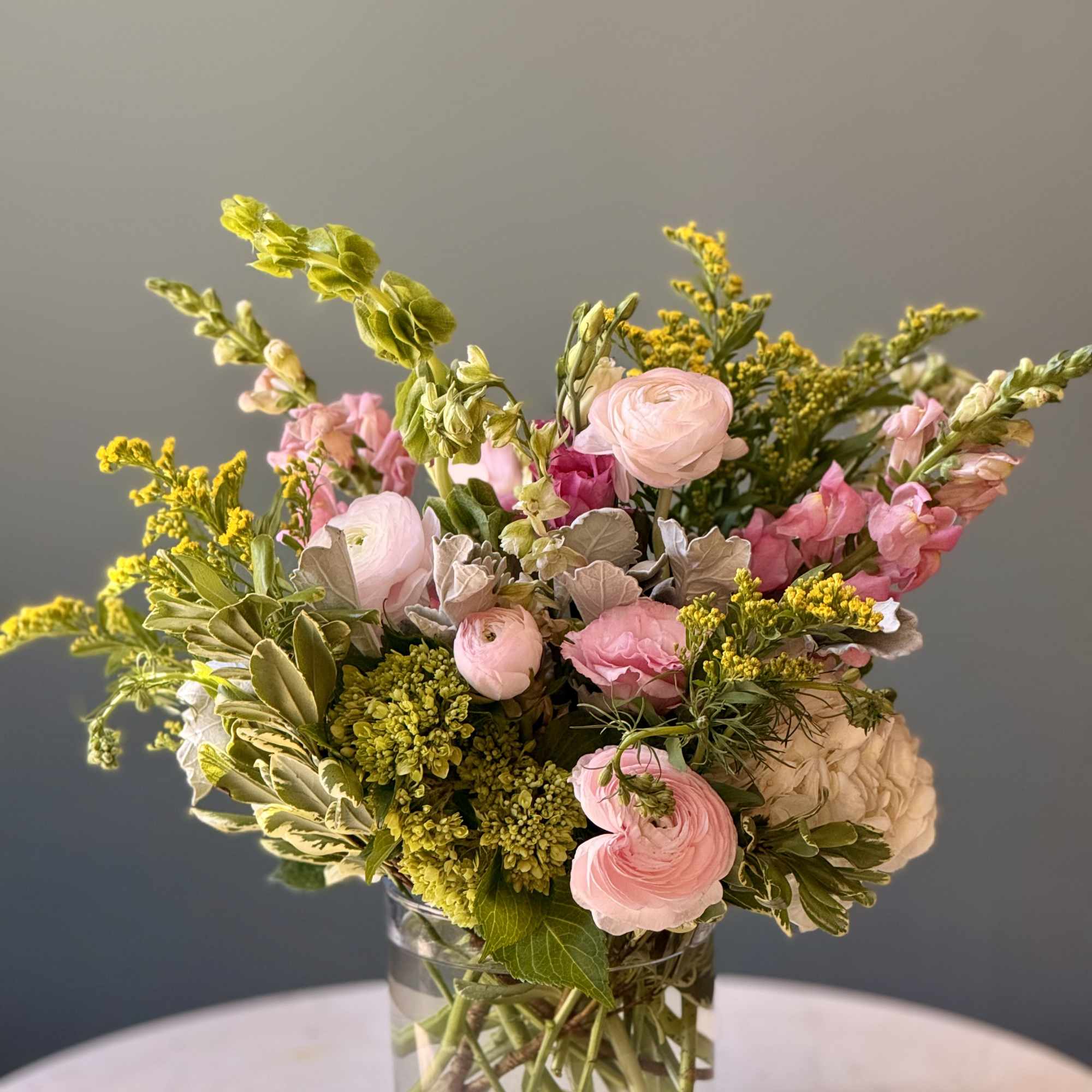 Pink and cream flowers in a clear glass vase