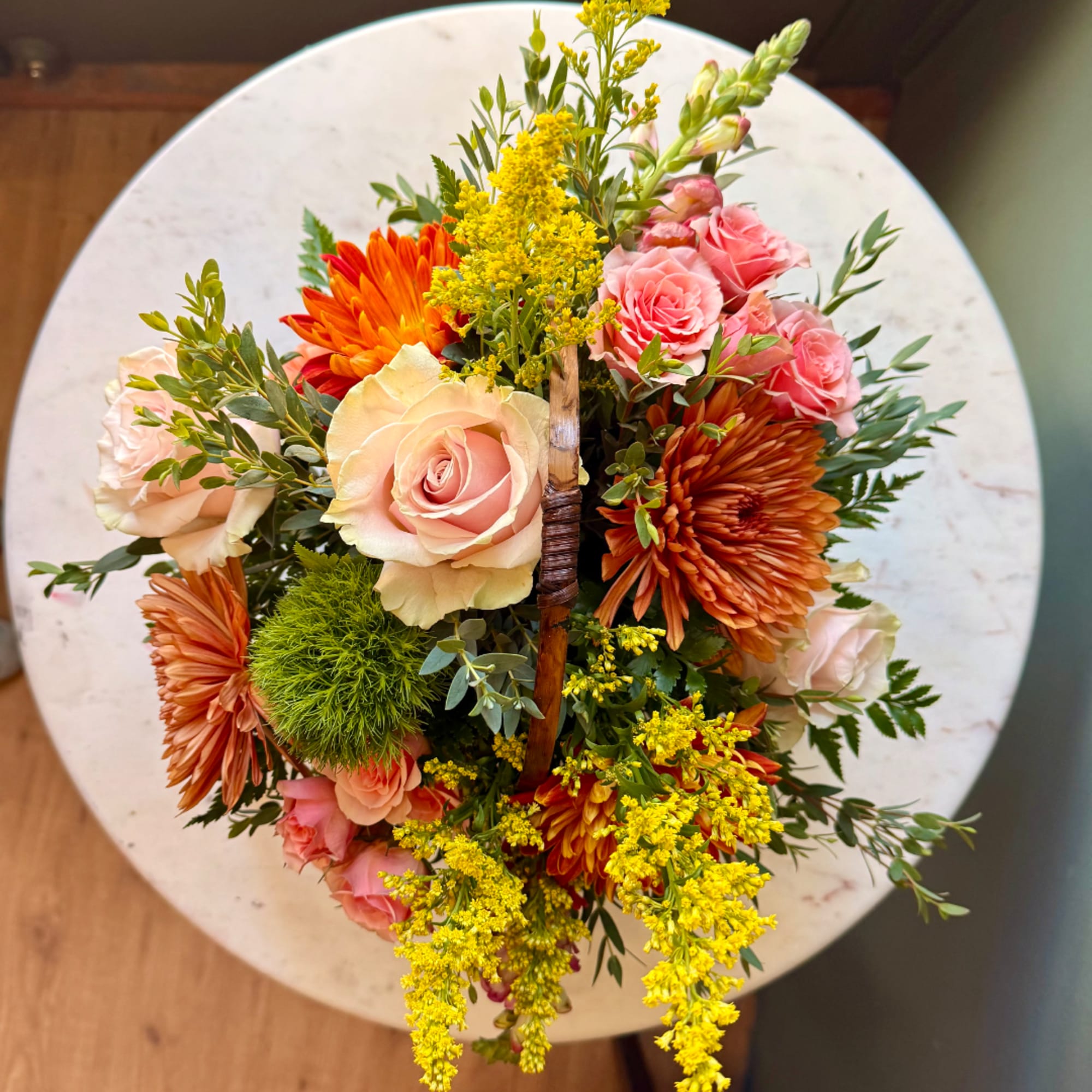 Mixed bouquet with pink roses, orange chrysanthemums, and yellow filler flowers