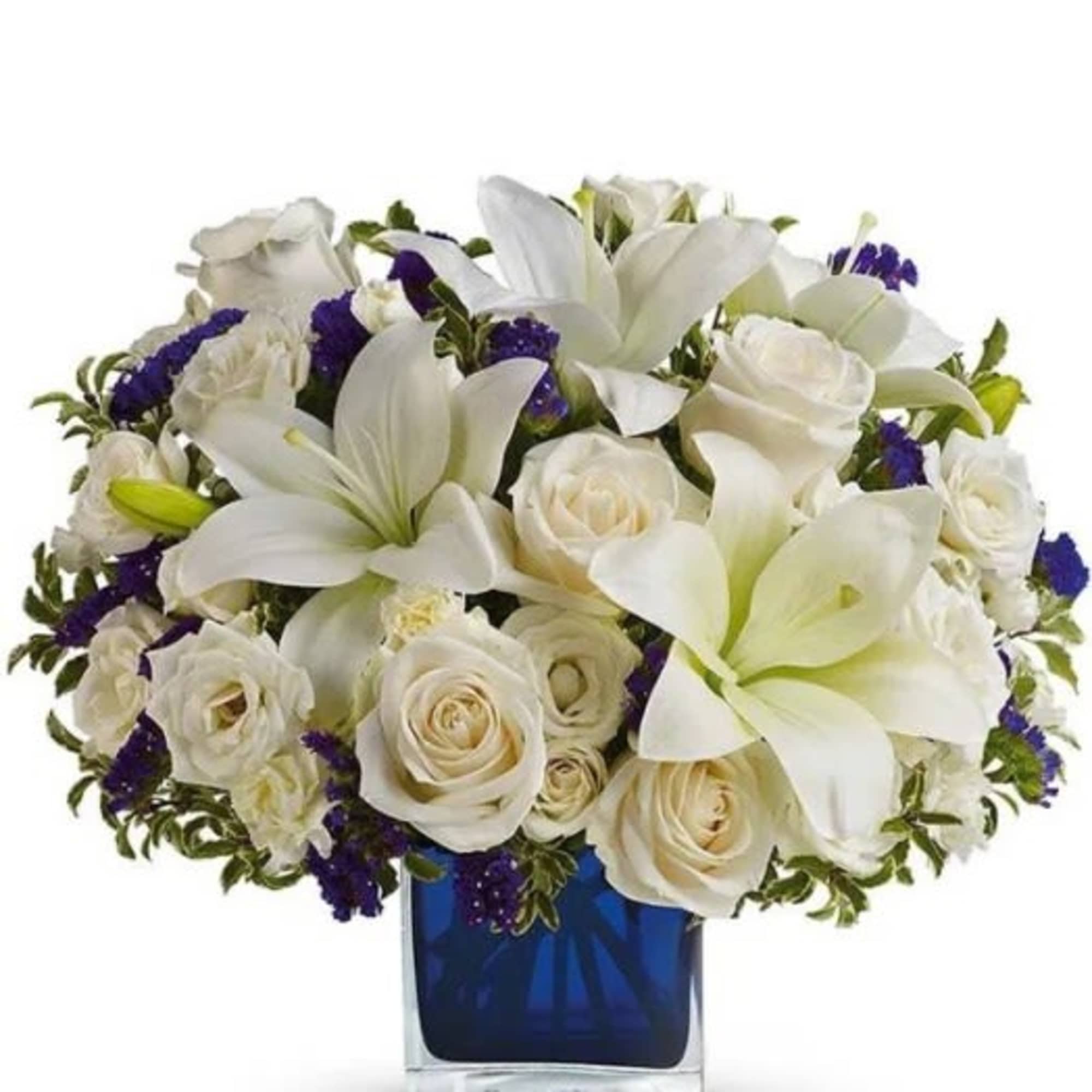 White lilies and roses arranged in a blue glass vase