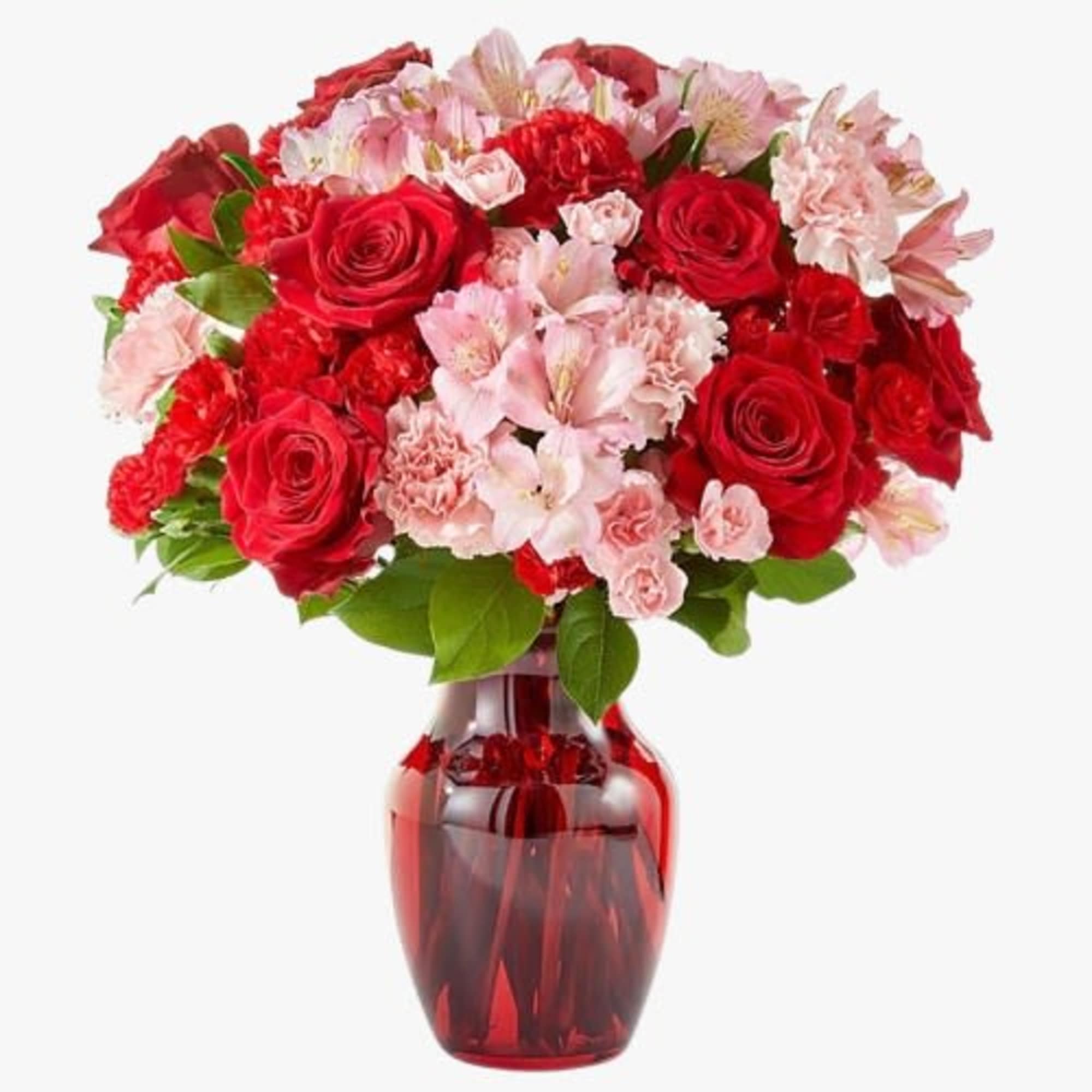 Red roses and pink flowers in a red glass vase