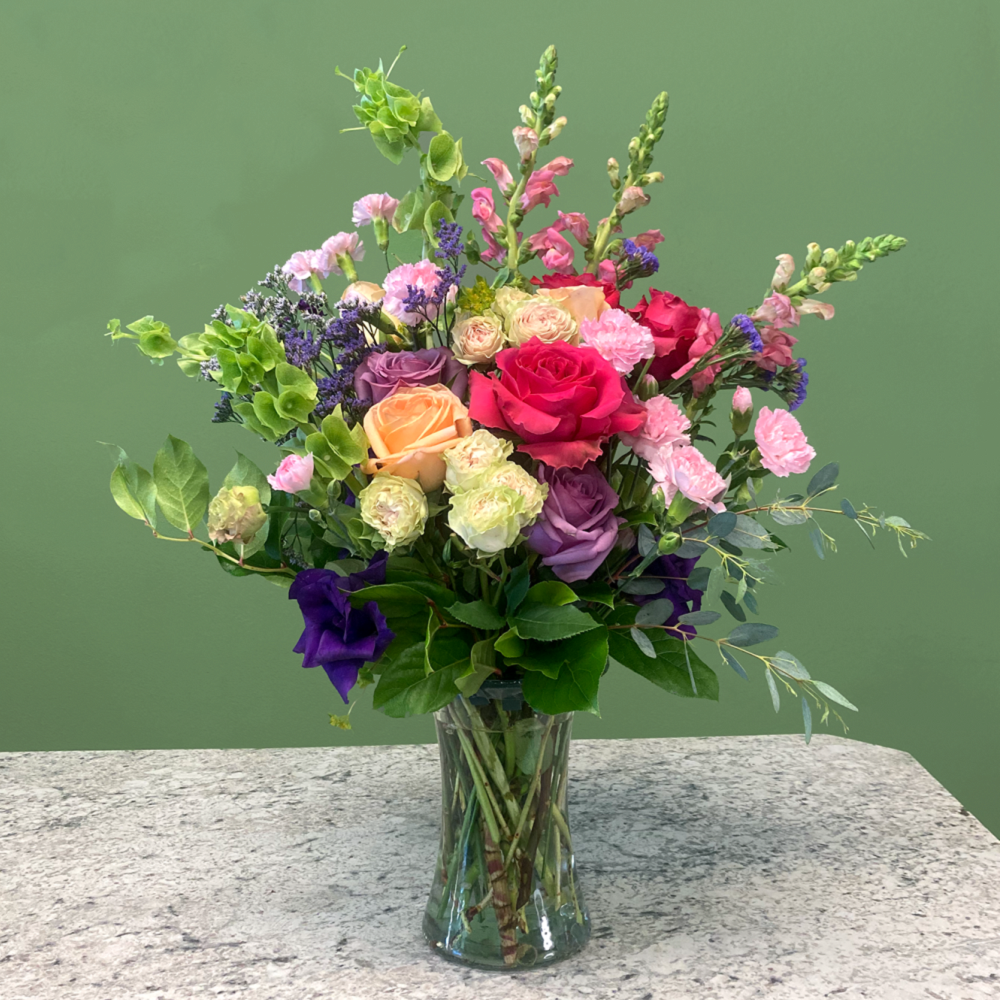 A charming mixed arrangement that showcases vibrant colors. Featuring roses, carnations, garden