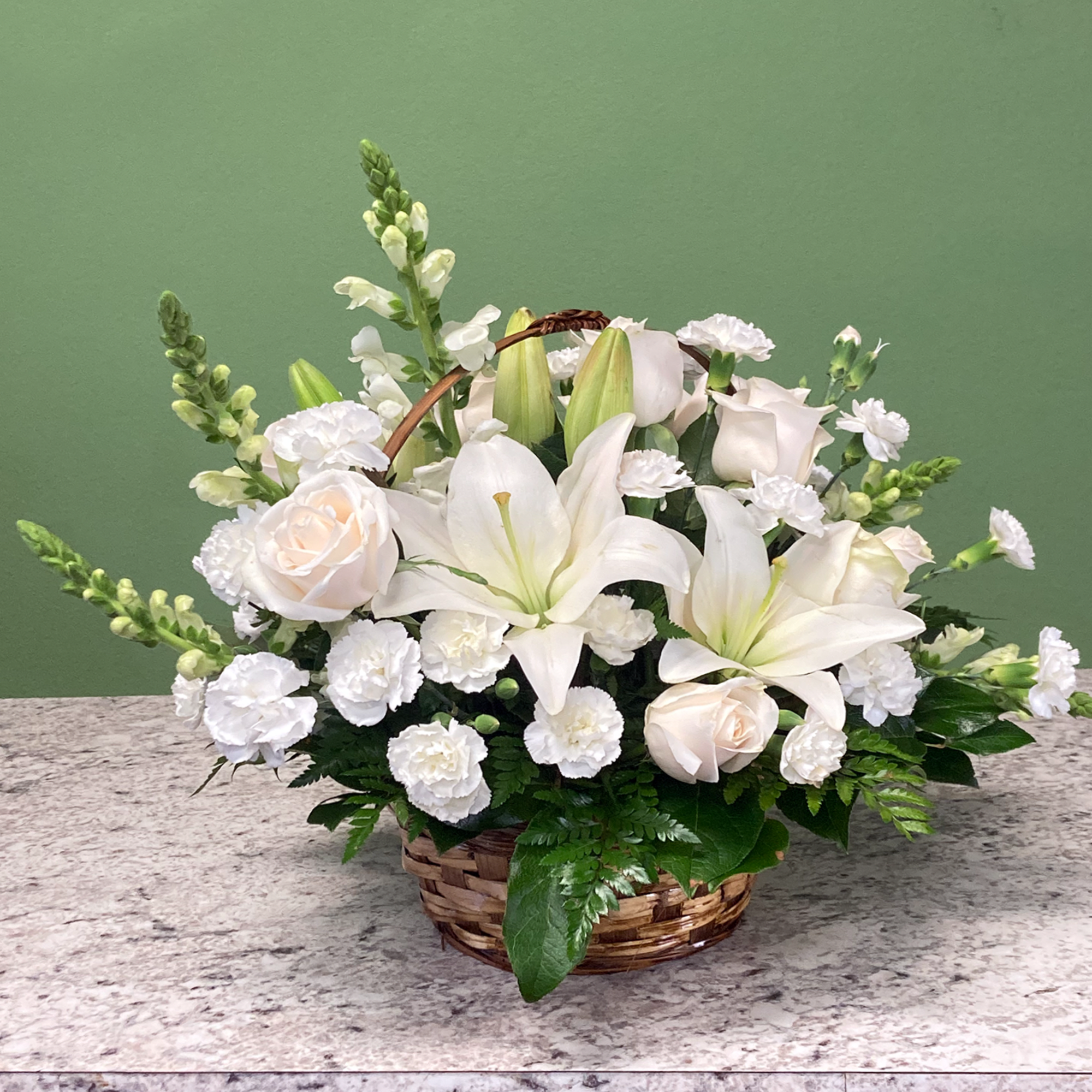 A tranquil mixed arrangement that arrives in a natural wicker basket, showcasing