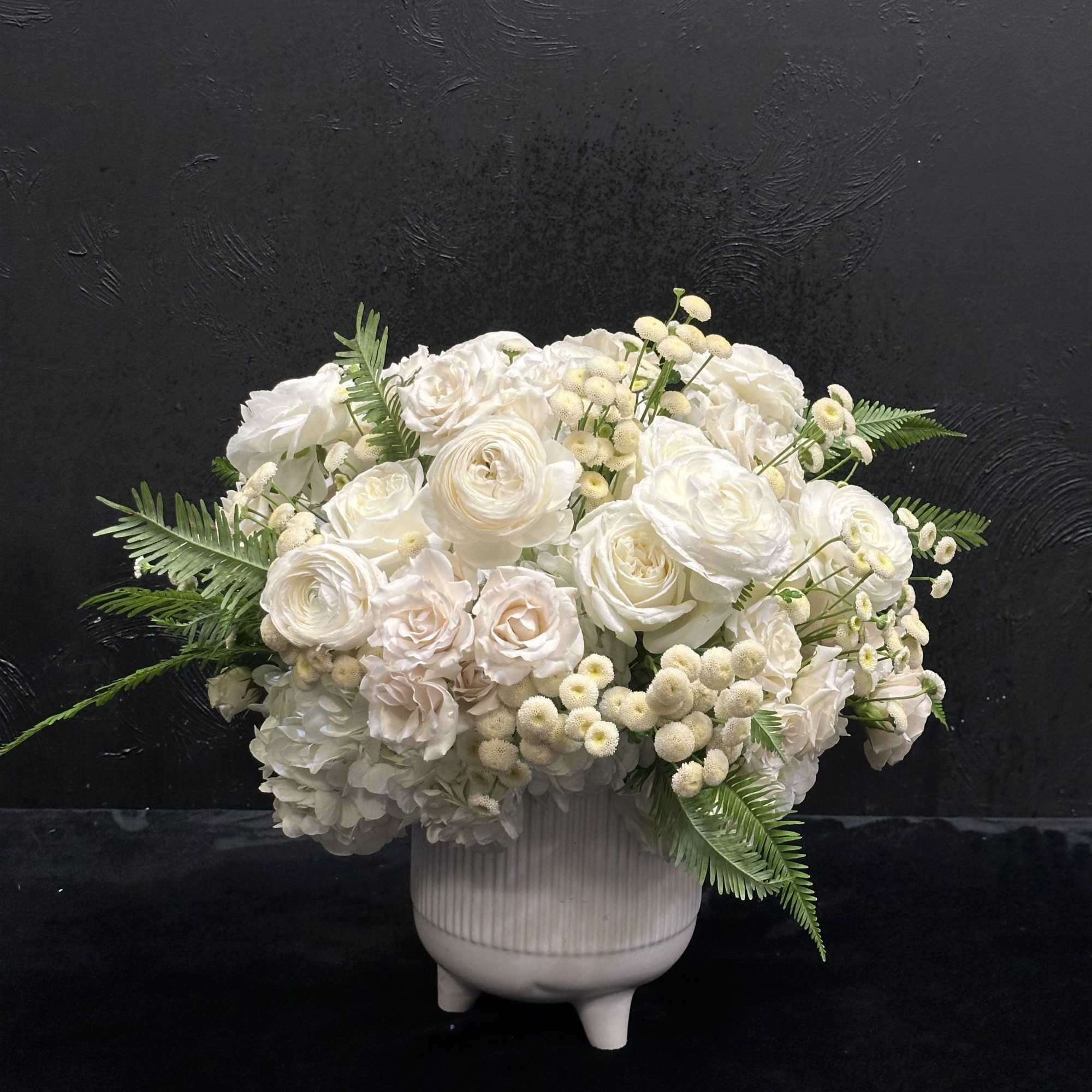 White floral arrangement in a ribbed ceramic vase