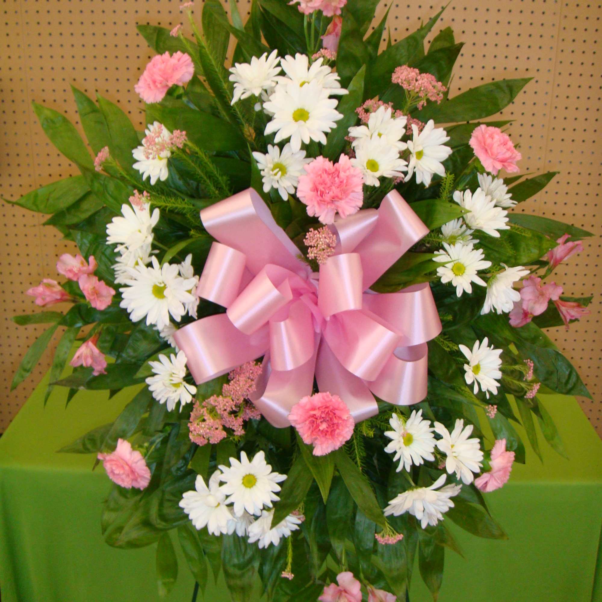 Pink and white daisy bouquet with a large pink ribbon