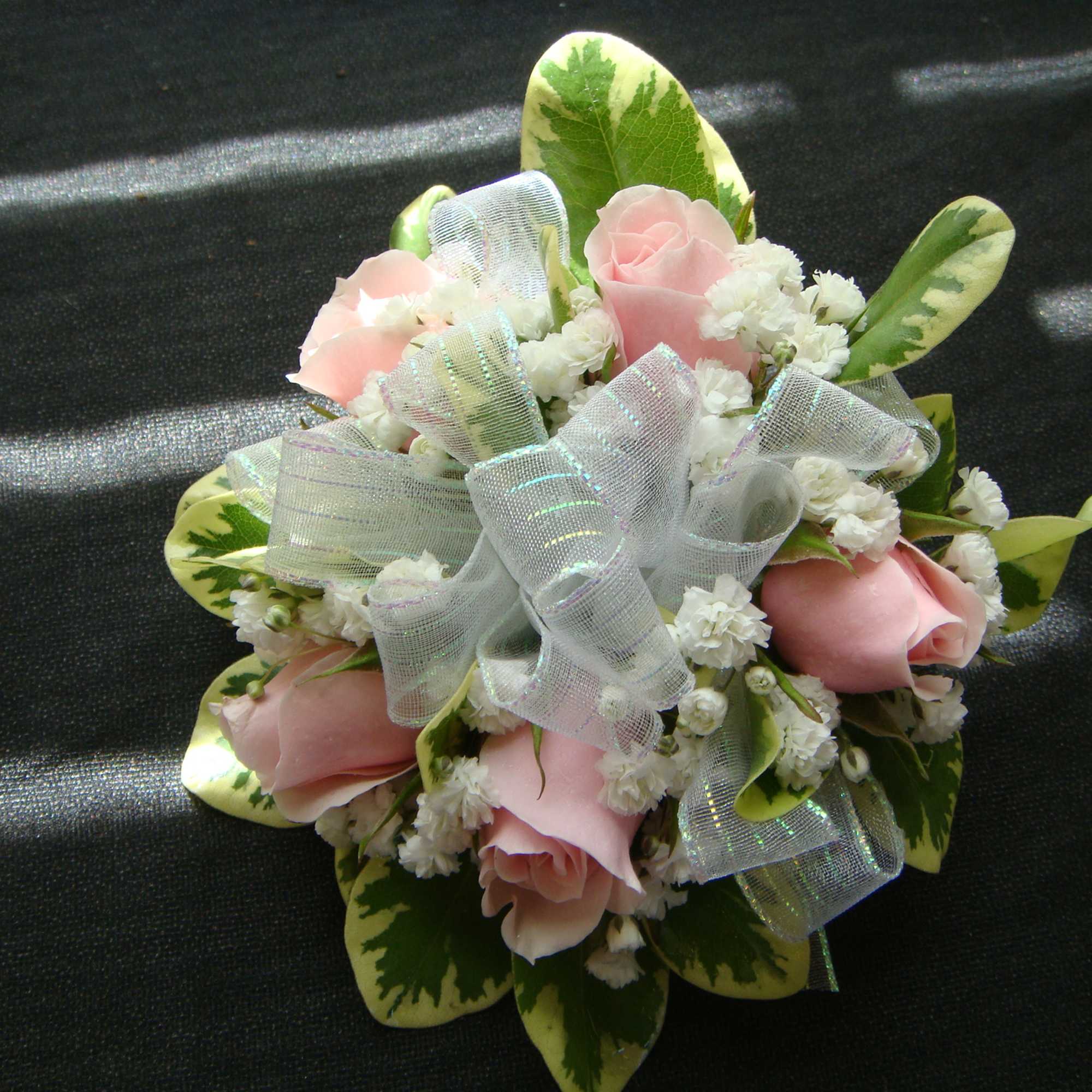 Small bouquet of pink roses with white filler flowers and ribbon