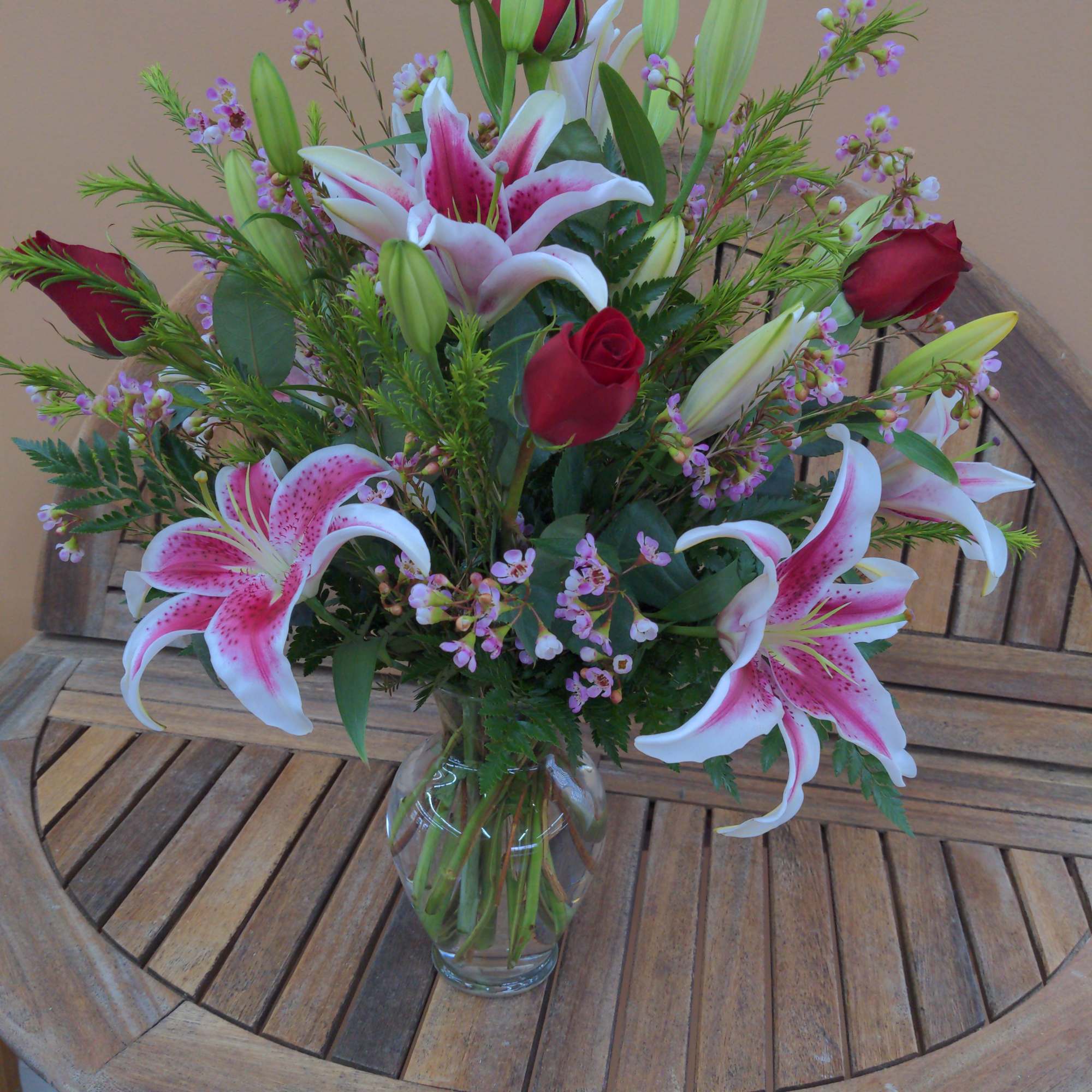 Bouquet of pink lilies and red roses in a clear glass vase, photo 3 of 3