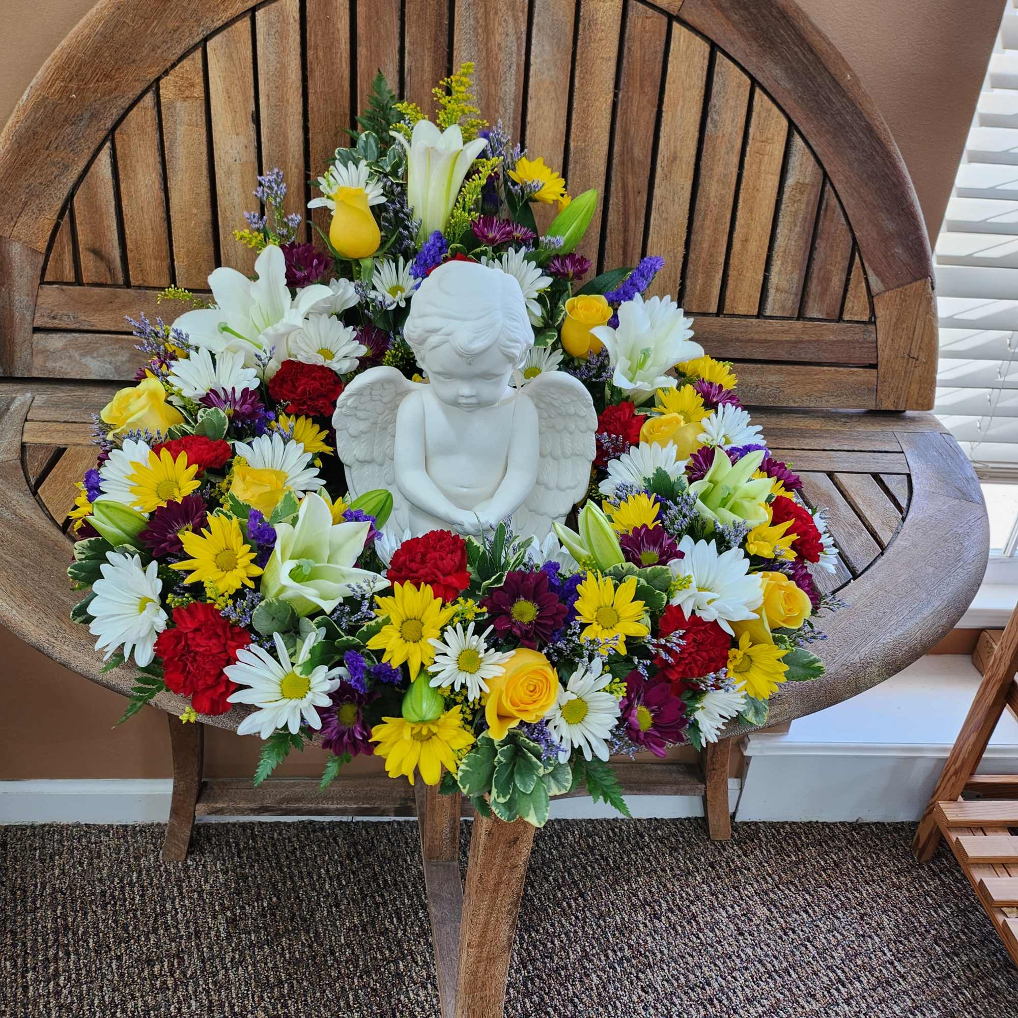 Colorful floral wreath with a white angel figurine in the center